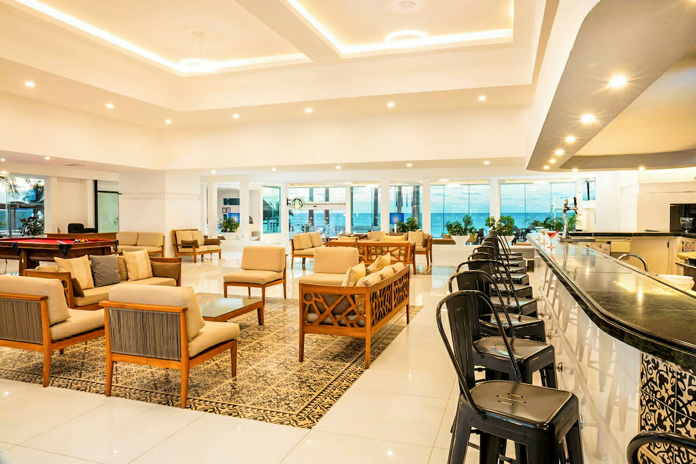 Et moderne hotel lobbyområde med siddegrupper og en bar. (AI-genereret tekst)