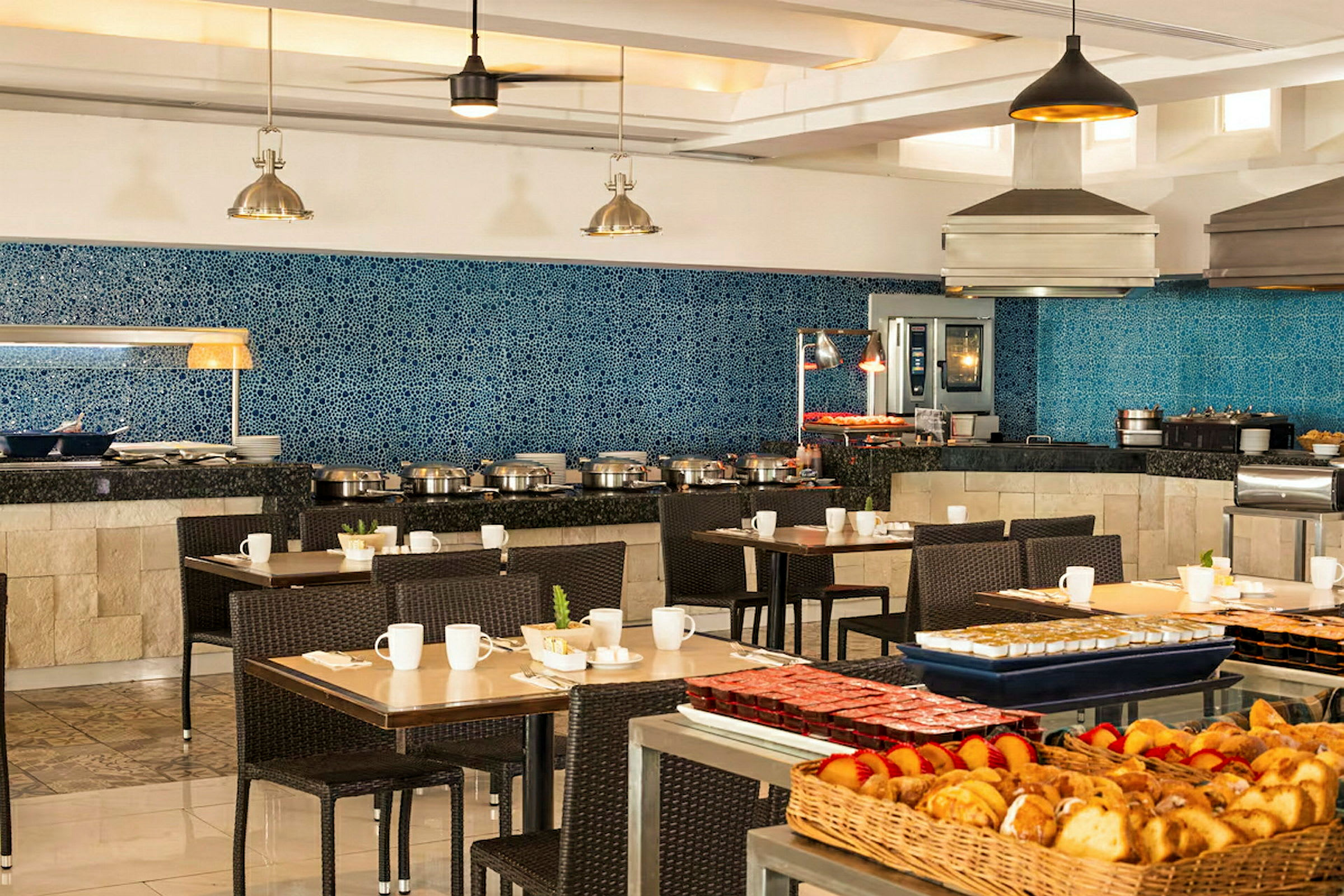 En restaurant med buffetservering og flere borde klar til gæster. (AI-genereret tekst)