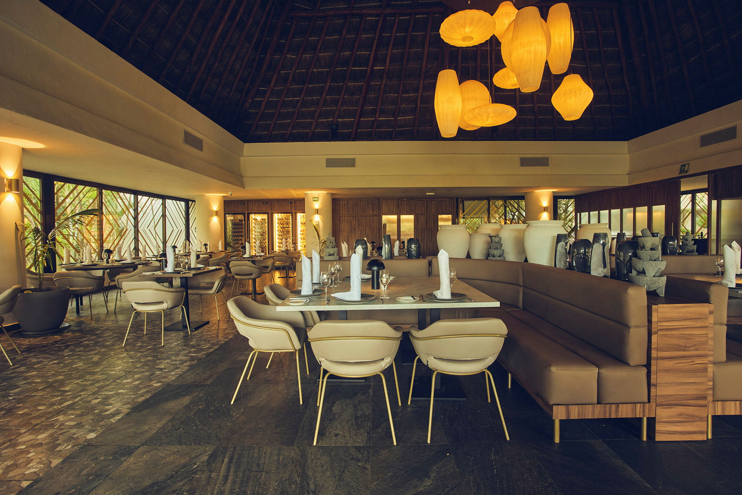 Billede af en elegant restaurant med dækkede borde, moderne stole og store dekorative vaser. Loftet er højt med synlige træstrukturer, og rummet har varm belysning. (AI-genereret tekst)