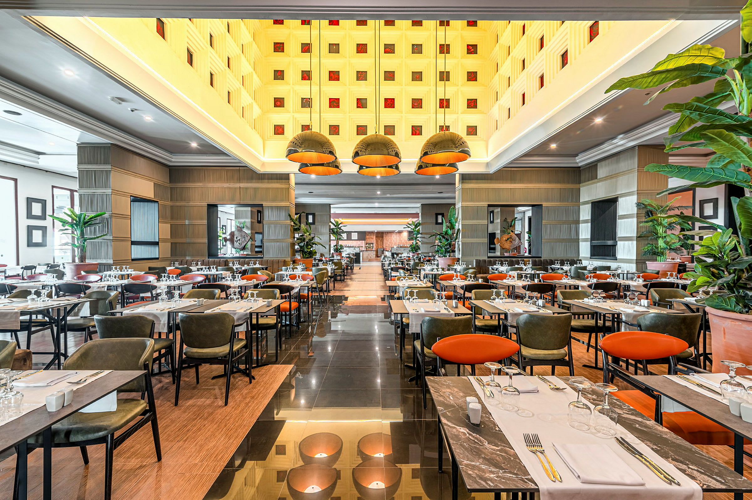 Billede af en restaurant med dækkede borde, stole og en moderne indretning. (AI-genereret tekst)