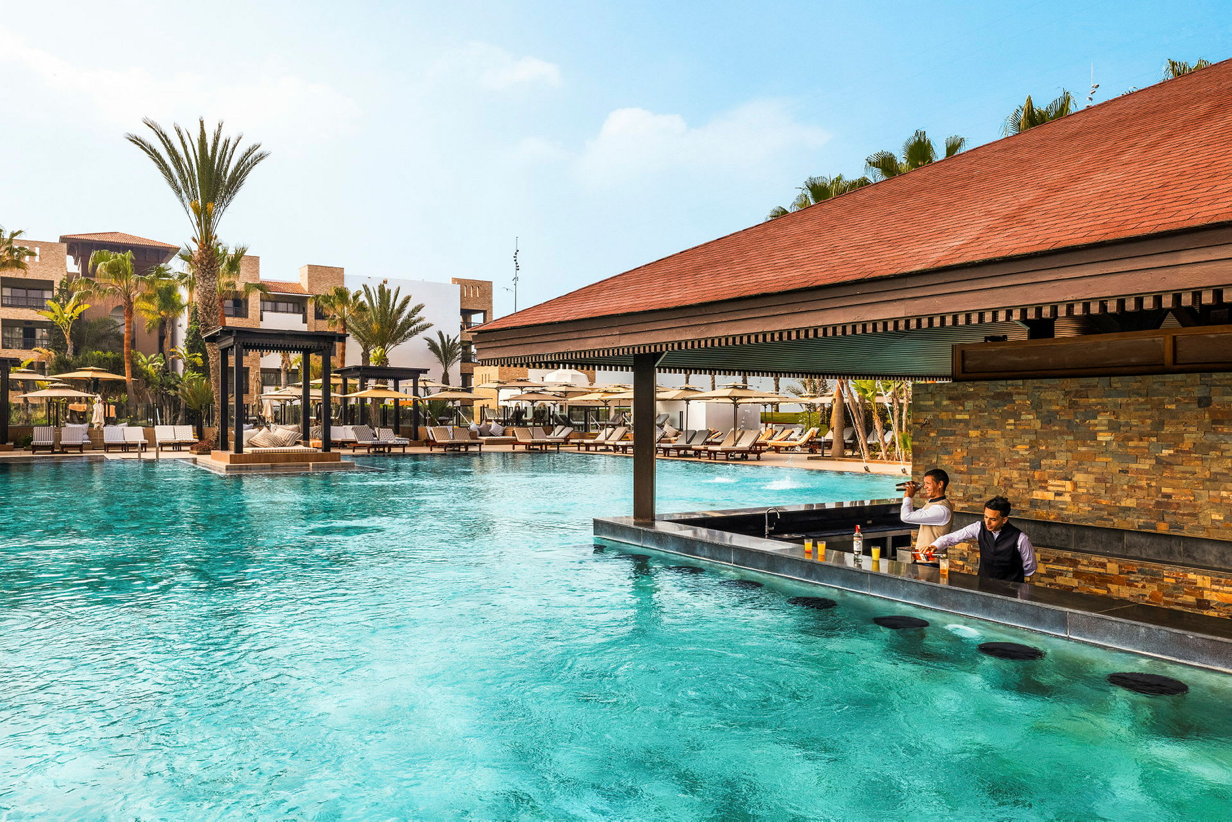 Pool med bar og liggestole i et feriekompleks. (AI-genereret tekst)