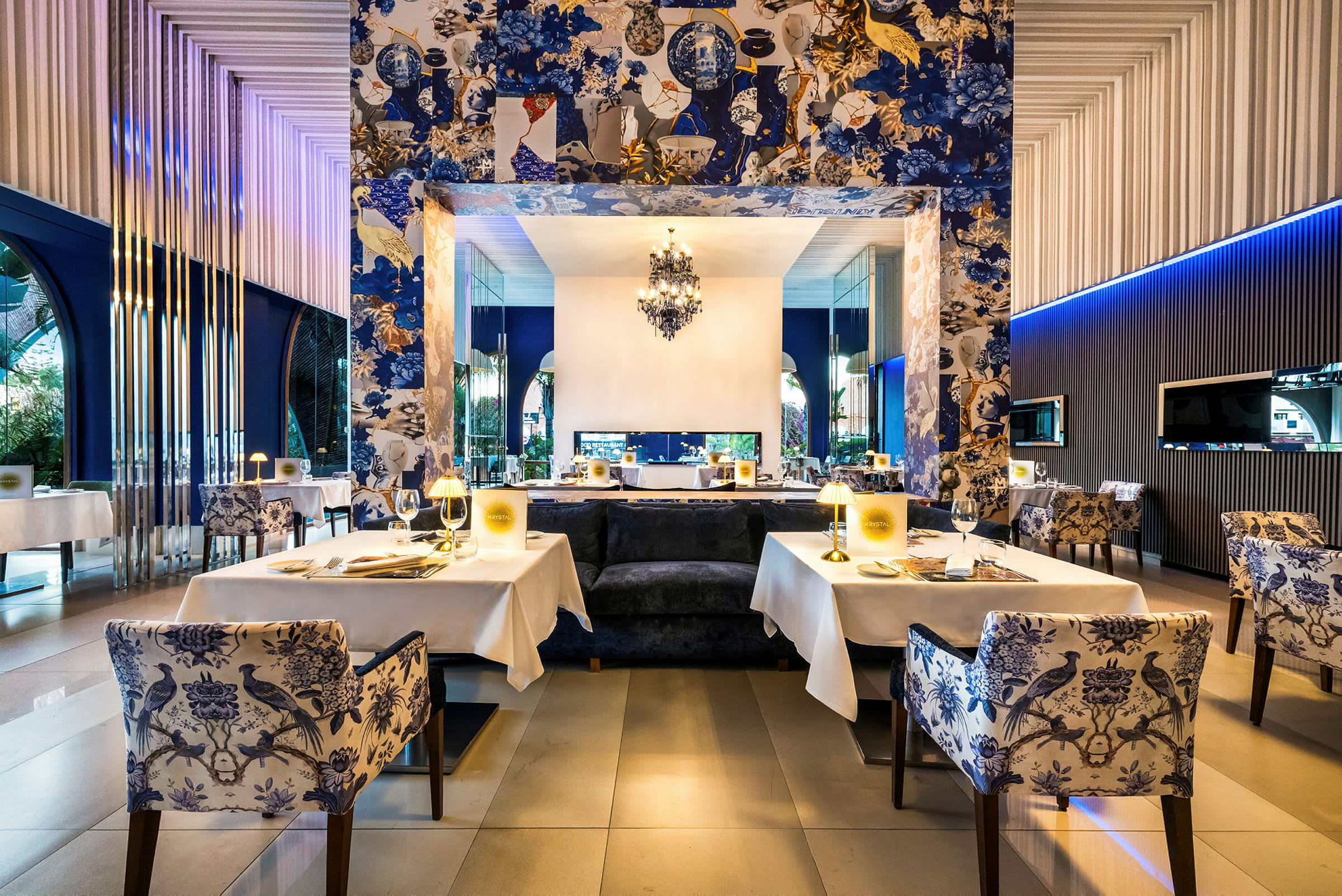 En elegant restaurant med dækkede borde, dekorative blå tapeter og belysning. (AI-genereret tekst)