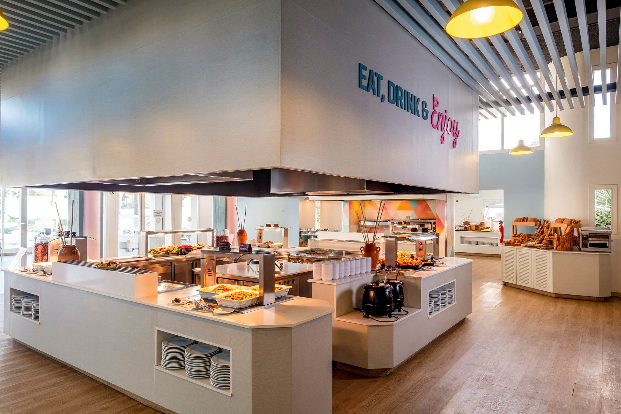 En cafeteria med selvbetjening, hvor mad præsenteres på diske, og brødudvalg kan ses på hylder. (AI-genereret tekst)