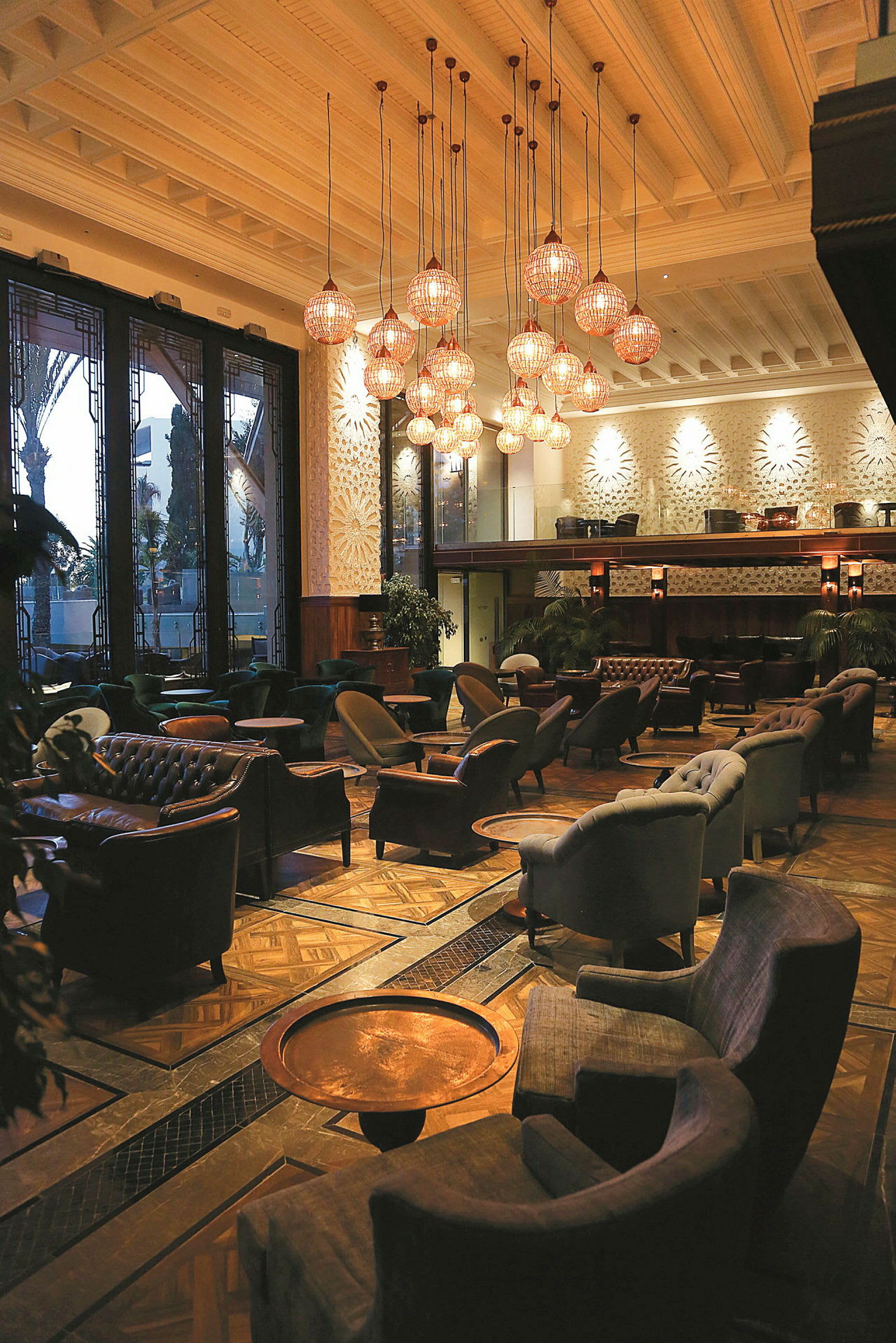 Interiør af en elegant lounge med komfortable siddepladser og belysning fra loftslamper. (AI-genereret tekst)