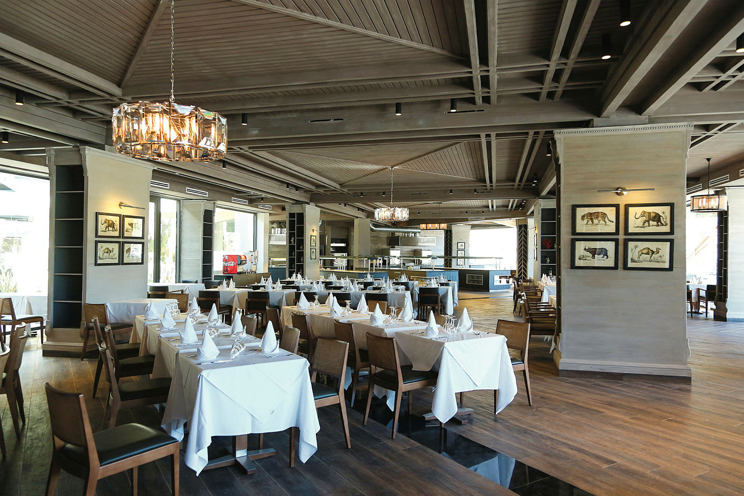 Restaurant med dækkede borde og elegante lysekroner. (AI-genereret tekst)