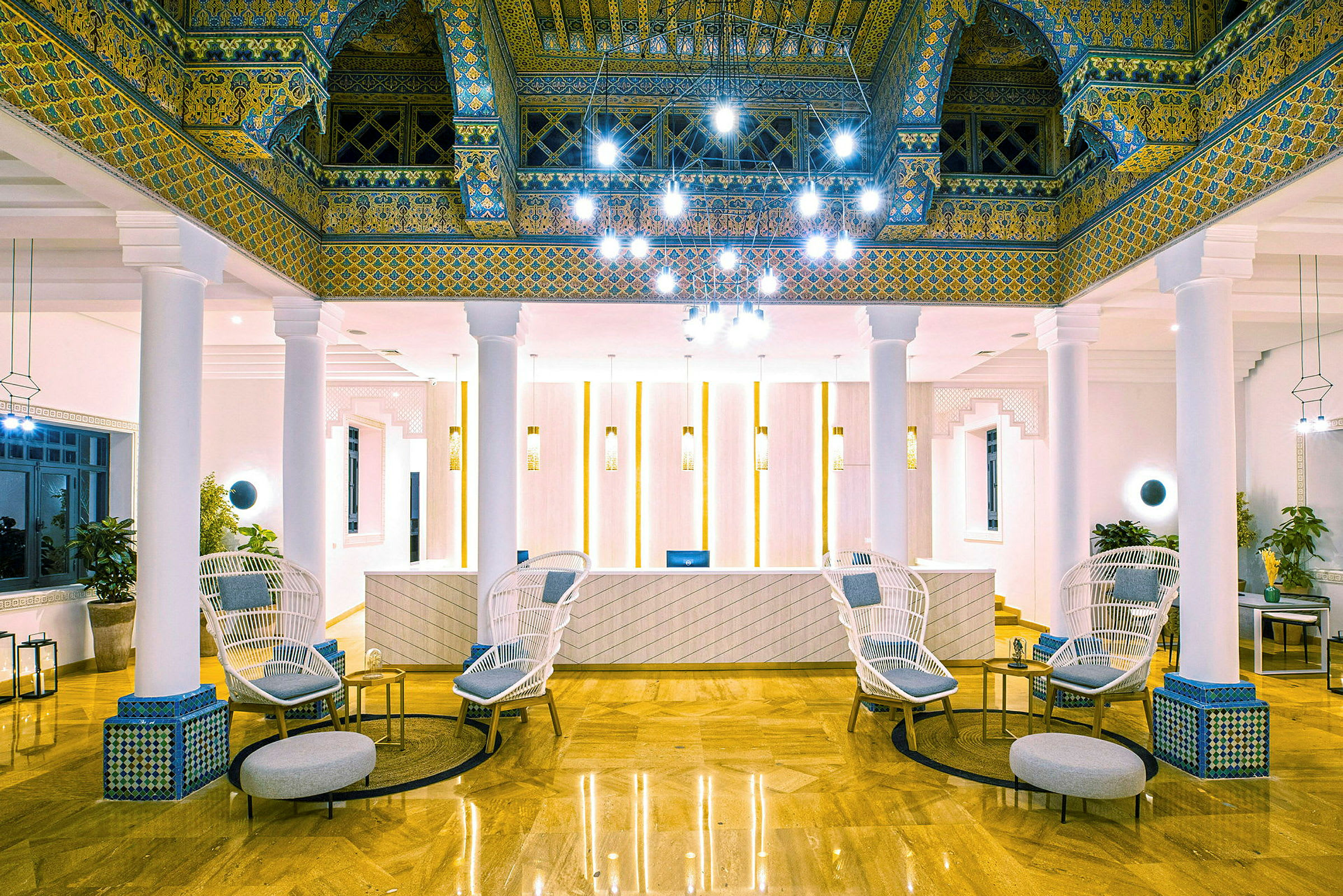 Lobbyen på et hotel med elegant indretning, herunder stole, borde og dekorative loftdetaljer. (AI-genereret tekst)
