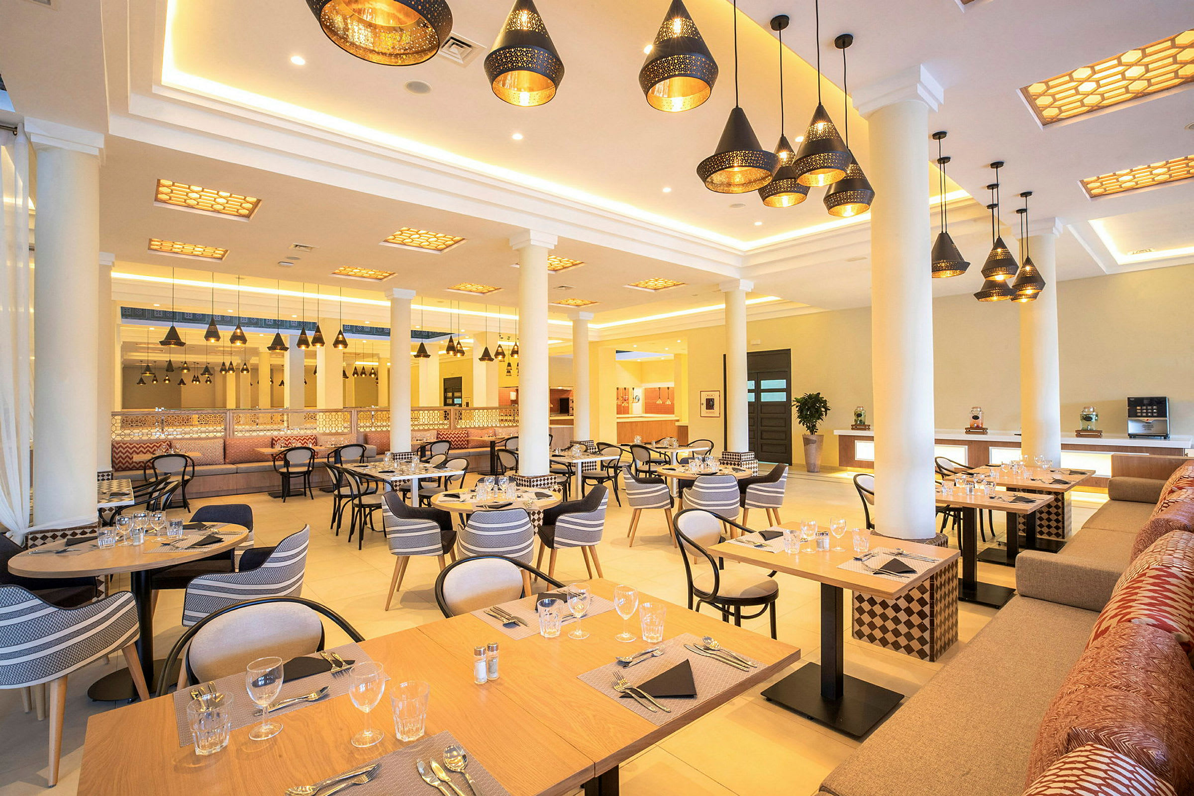 Restaurant med dækkede borde og hængende loftslamper. (AI-genereret tekst)