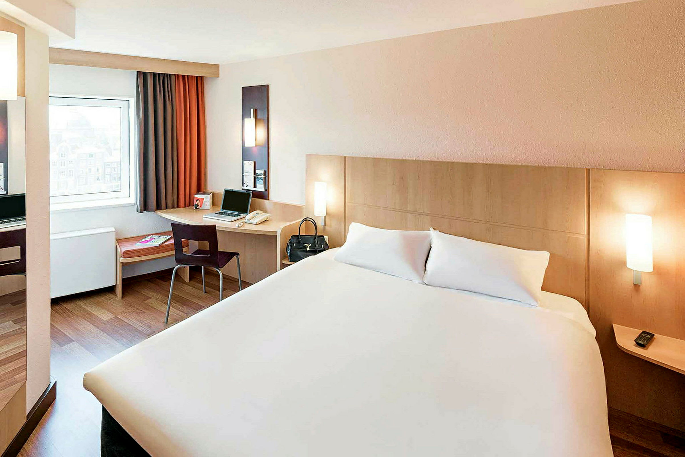 Hotelværelse med en dobbeltseng, et skrivebord med en stol og et vindue. (AI-genereret tekst)