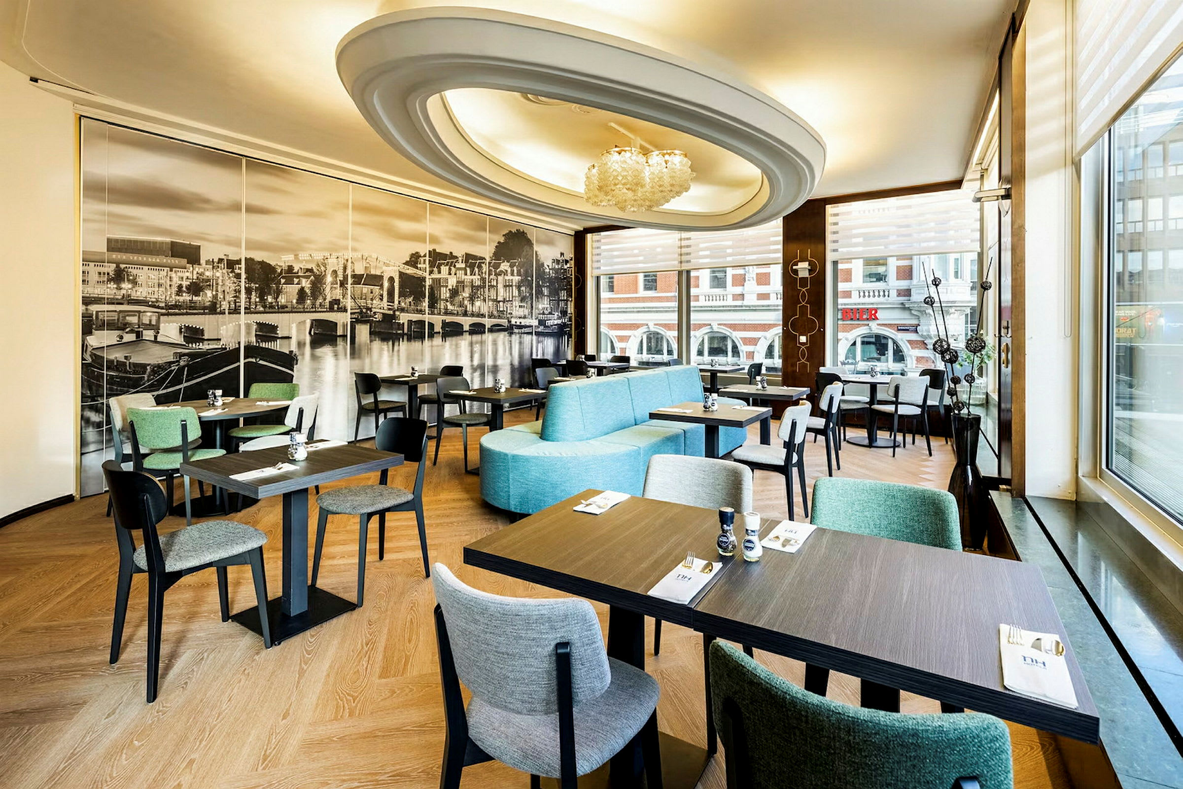 En restaurantindretning med moderne møbler og stort fototapet af et bybillede på væggen. (AI-genereret tekst)