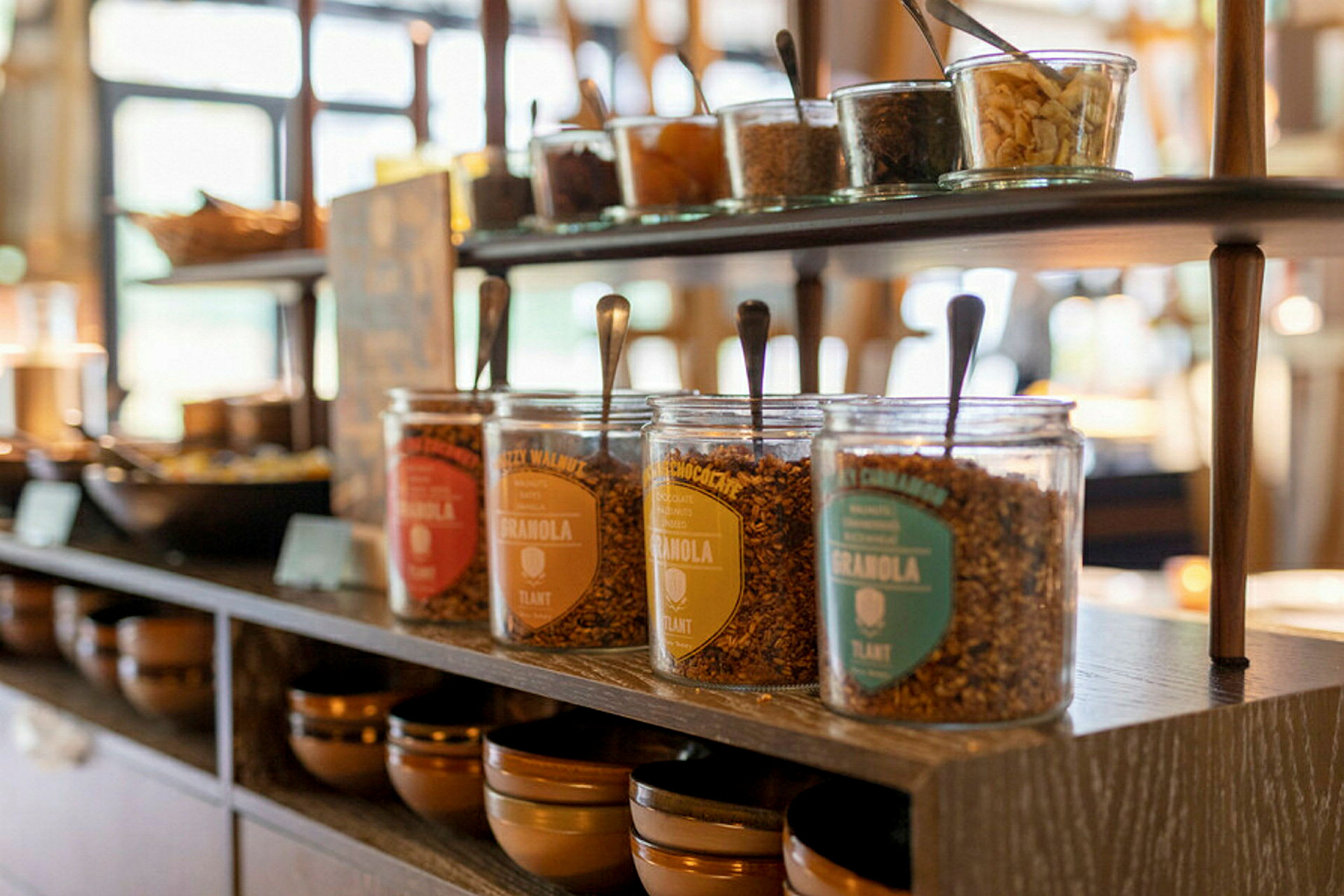 Flere glasbeholdere med granola på en hylde i nærbillede. (AI-genereret tekst)