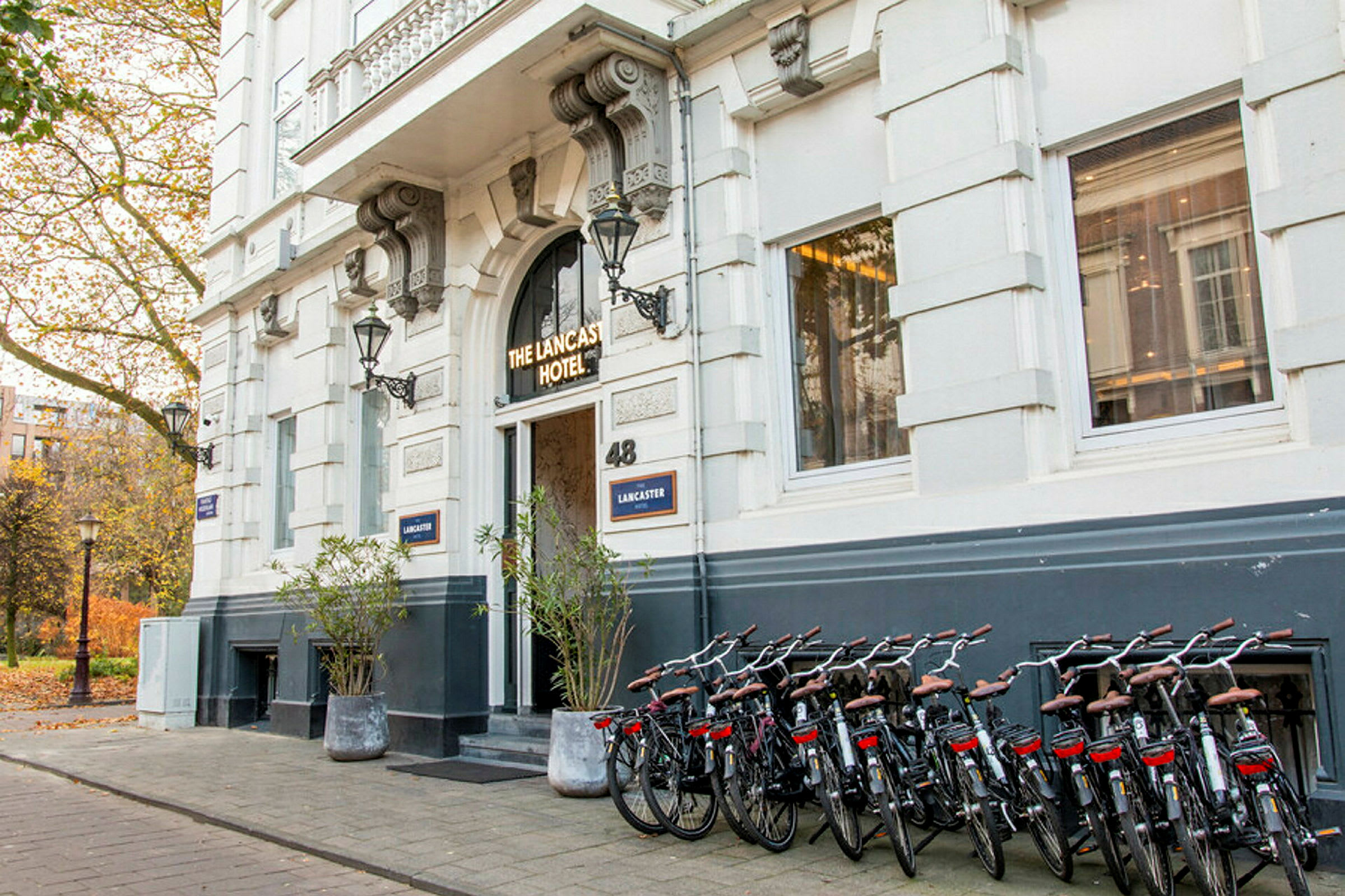 Indgang til et hotel med cykler parkeret langs bygningens facade. (AI-genereret tekst)