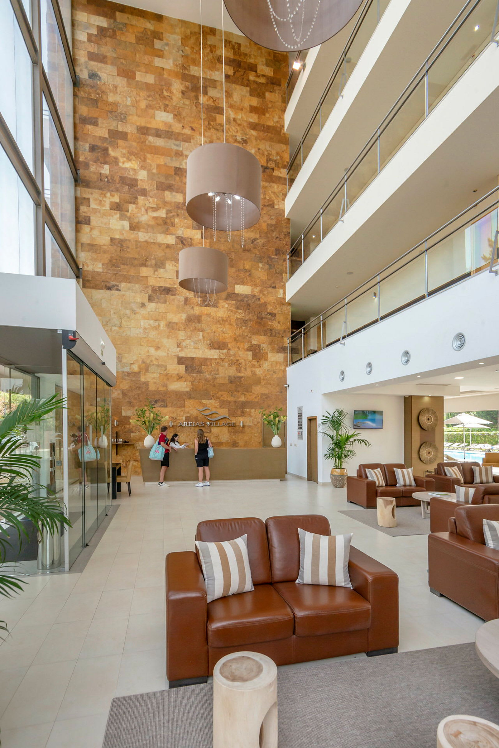 Lys hotellets lobby med siddeområde og receptionsskranke. (AI-genereret tekst)
