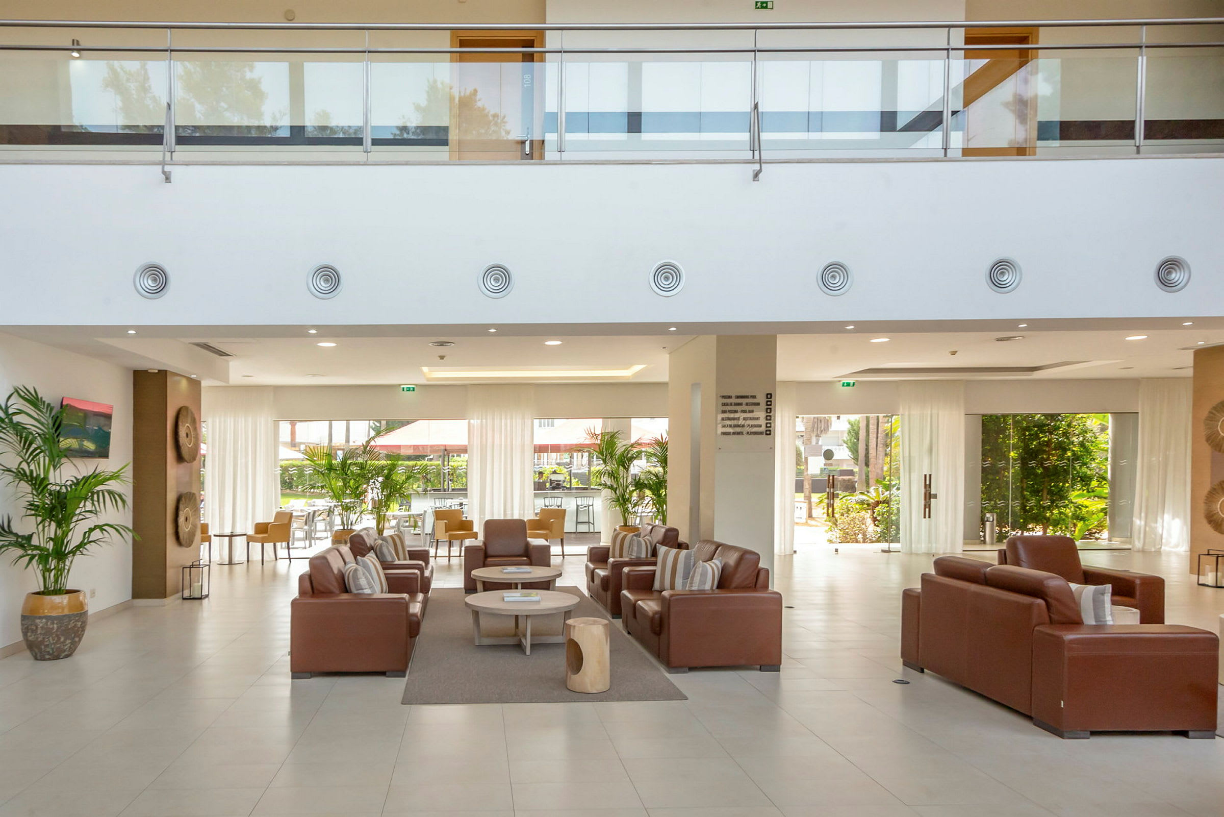 Hotellobby med siddegrupper og store vinduer. (AI-genereret tekst)