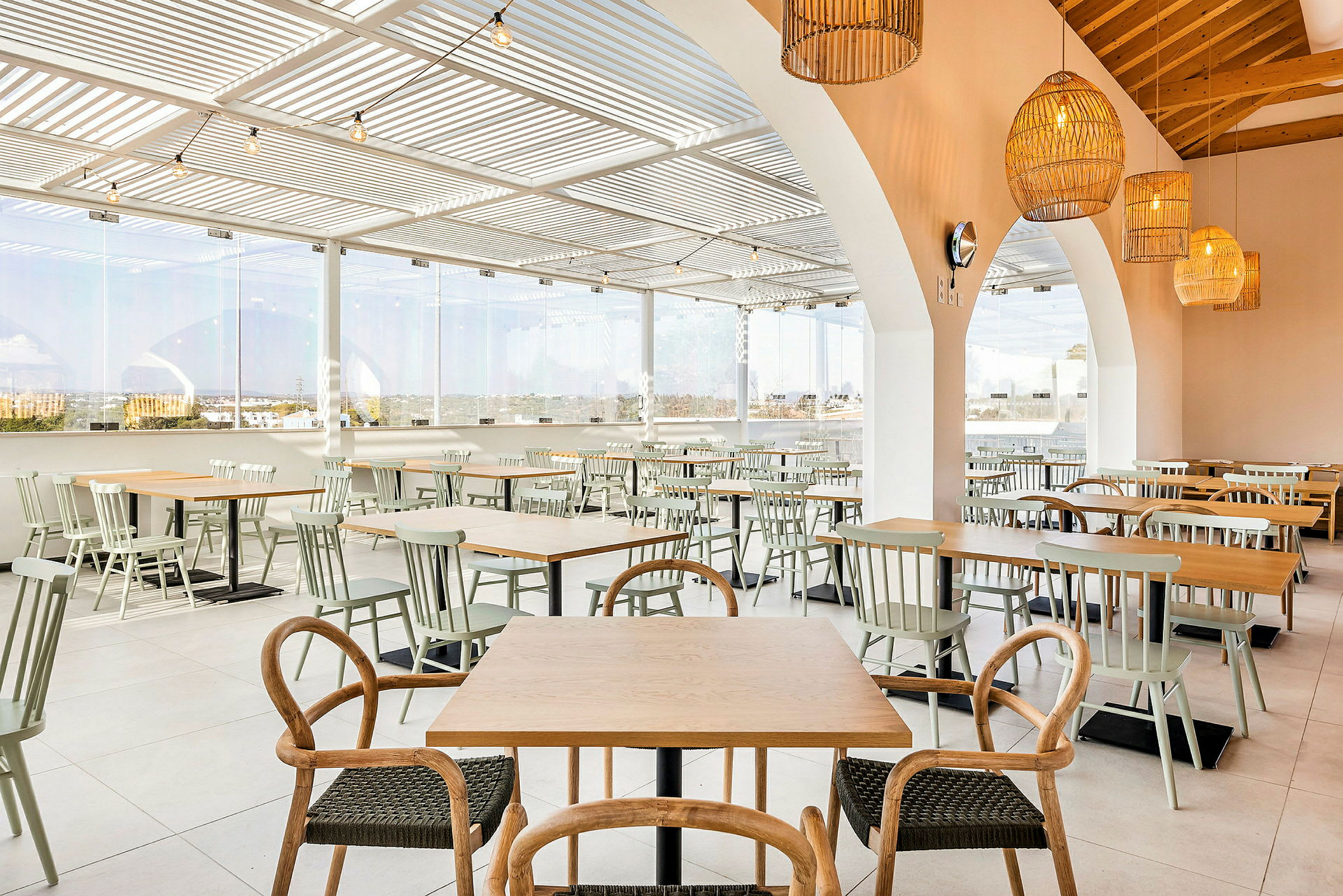 Billede af en restaurant med borde og stole i et åbent og lyst rum. (AI-genereret tekst)