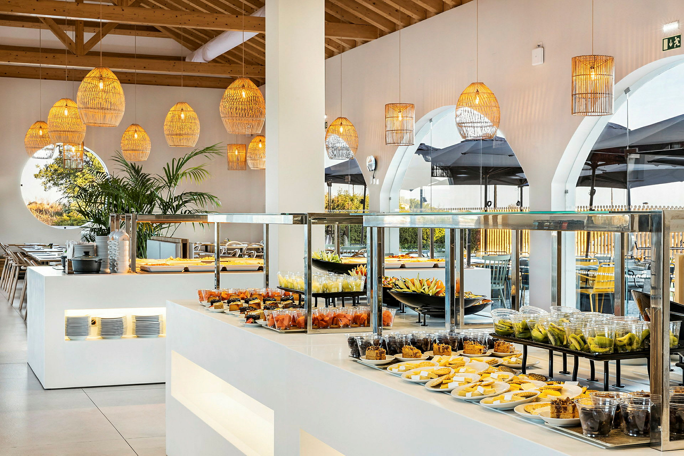 Buffet med forskellige frugter og bagværk i en lys og moderne spisesal. (AI-genereret tekst)