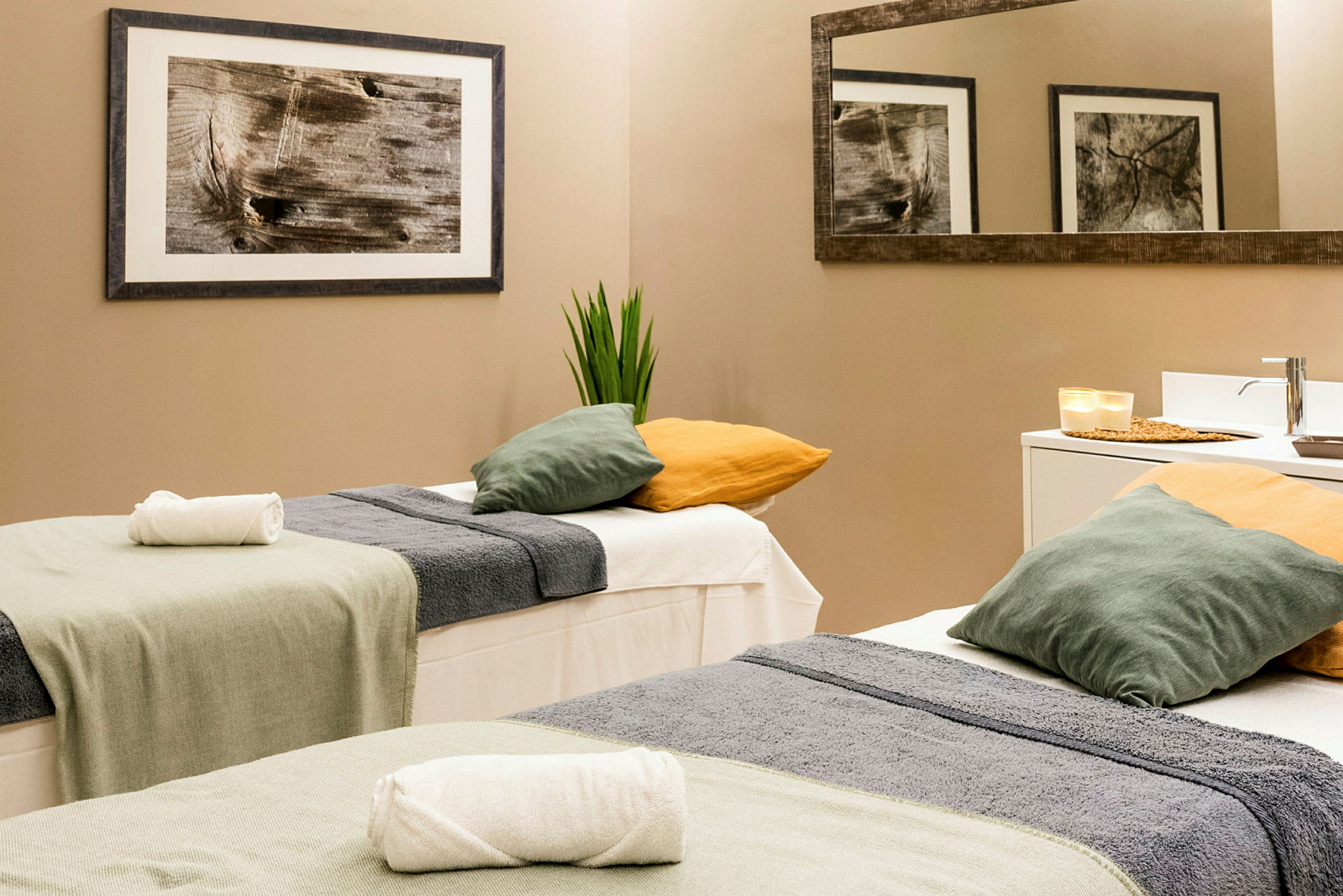 To massageborde med håndklæder og puder i et lyst rum. (AI-genereret tekst)