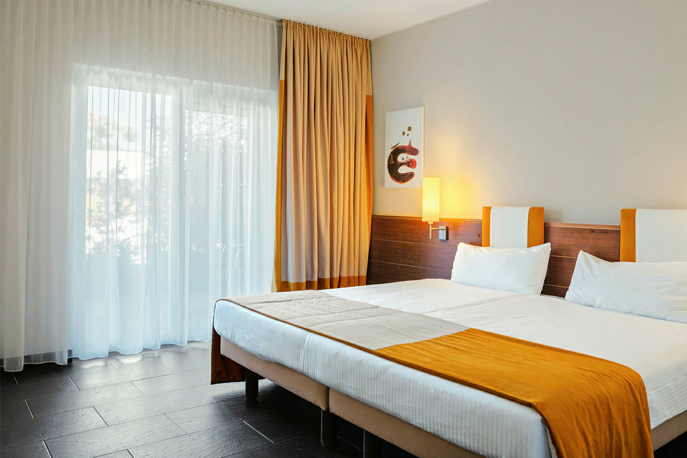 Et hotelværelse med en dobbeltseng og orange detaljer. (AI-genereret tekst)