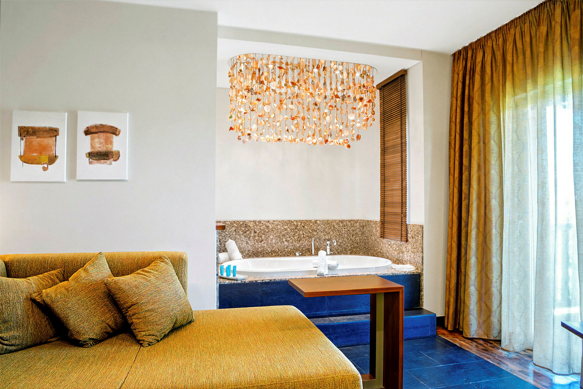 Interiør af et hotelværelse med en siddegruppe, kunst på væggen, et boblebad og en dekorativ loftlampe. (AI-genereret tekst)