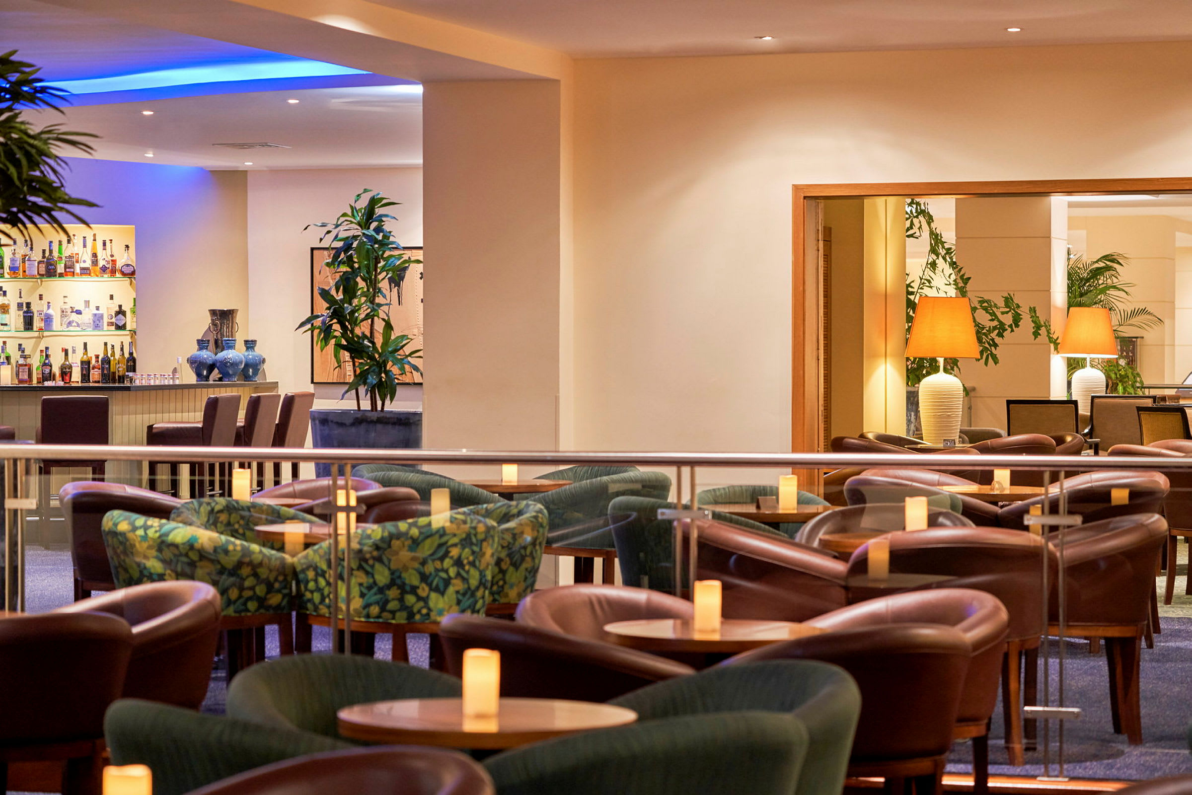 Indretning af hotelbar med siddegrupper og borde. (AI-genereret tekst)