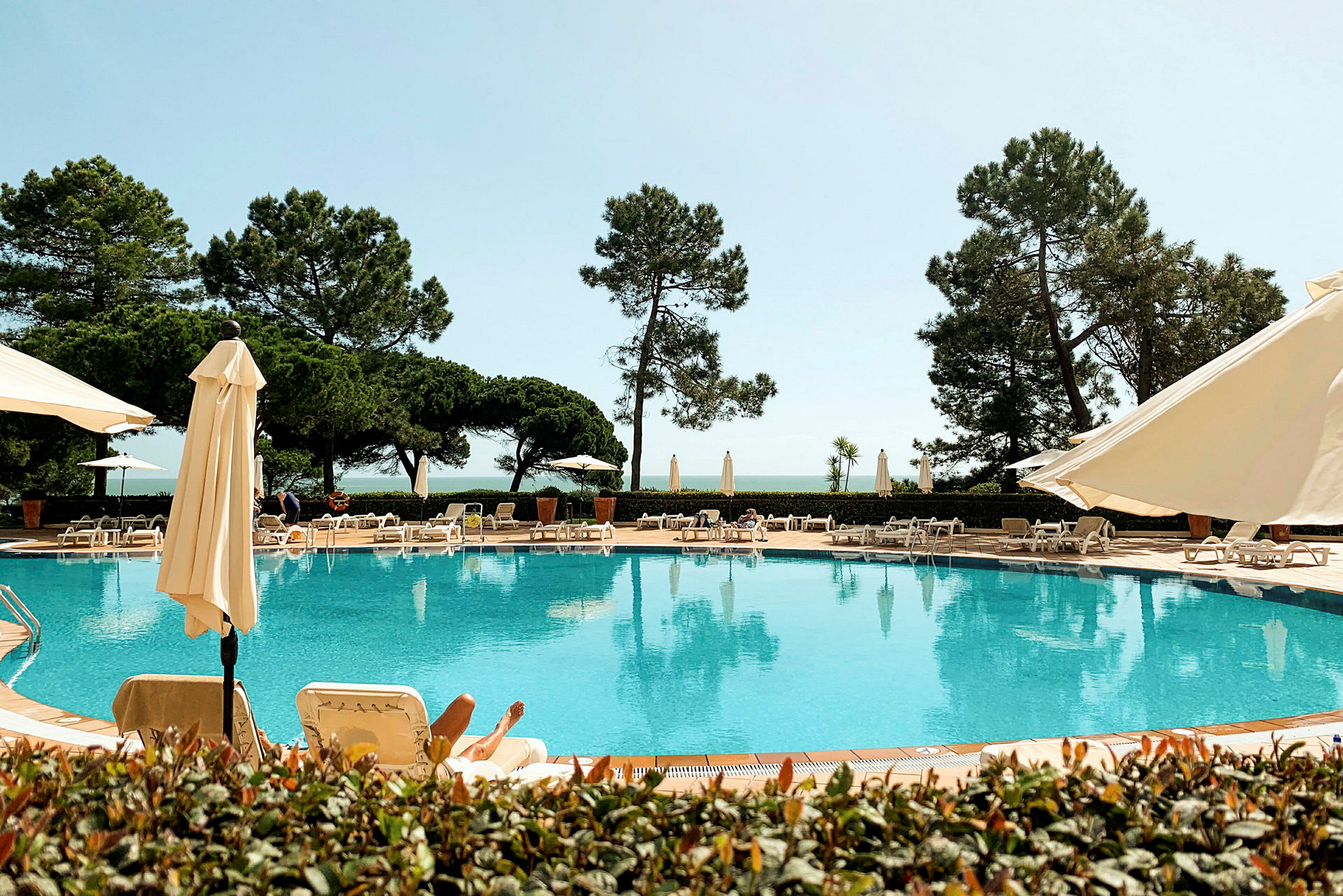 Udendørs pool ved et hotel med liggestole og parasoller. (AI-genereret tekst)