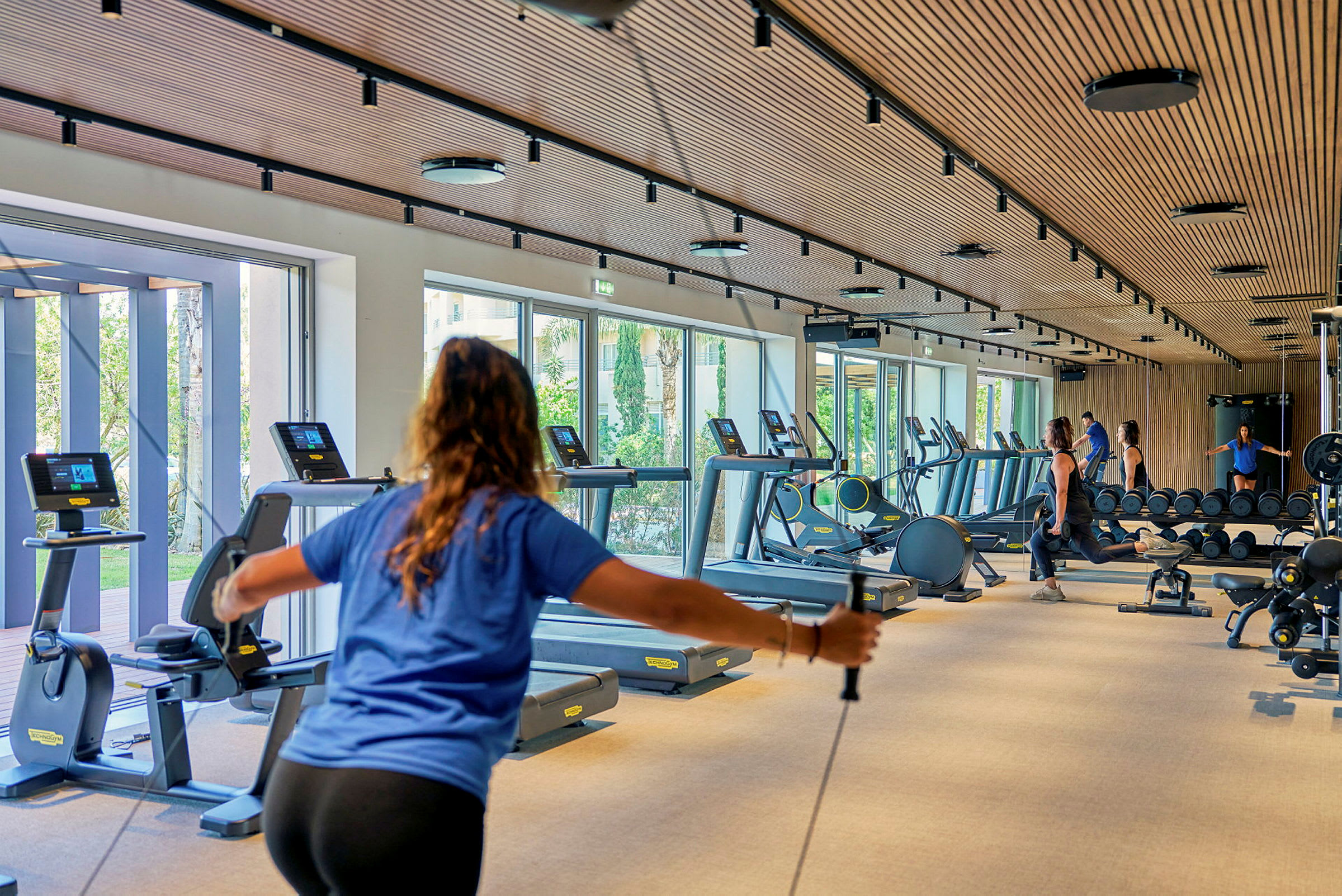 Fitnesscenter med træningsudstyr og personer, der træner. (AI-genereret tekst)