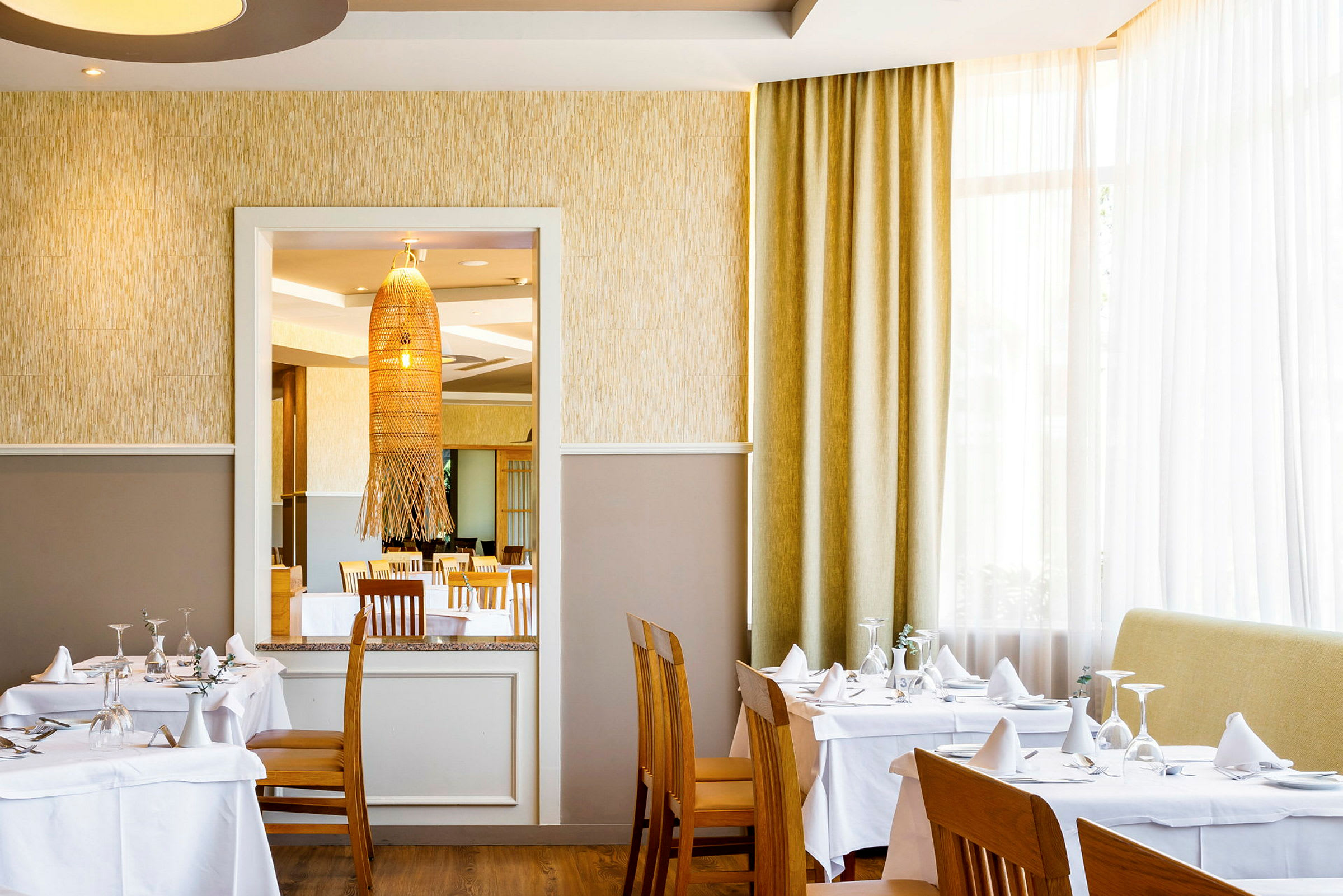 Interiør af en restaurant med dækkede borde og stole. (AI-genereret tekst)