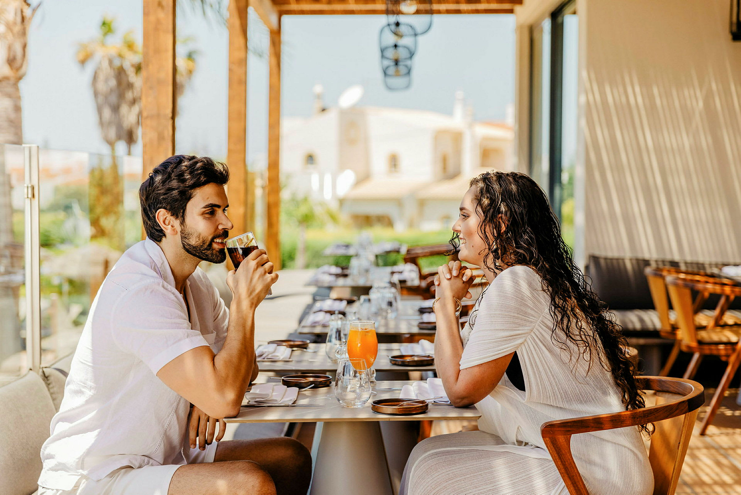 To personer sidder ved et dækket restaurantbord og drikker drikkevarer. (AI-genereret tekst)