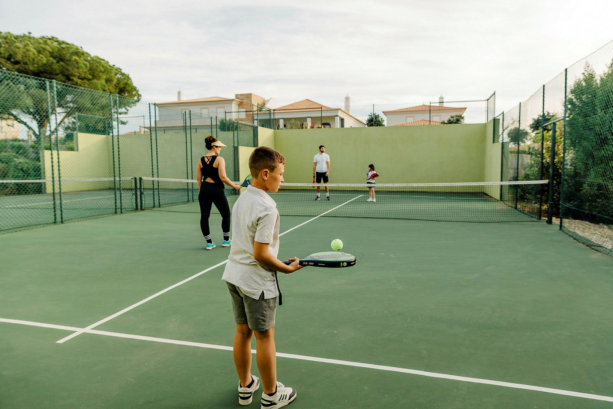 En tennisbane med mennesker, der spiller tennis. (AI-genereret tekst)