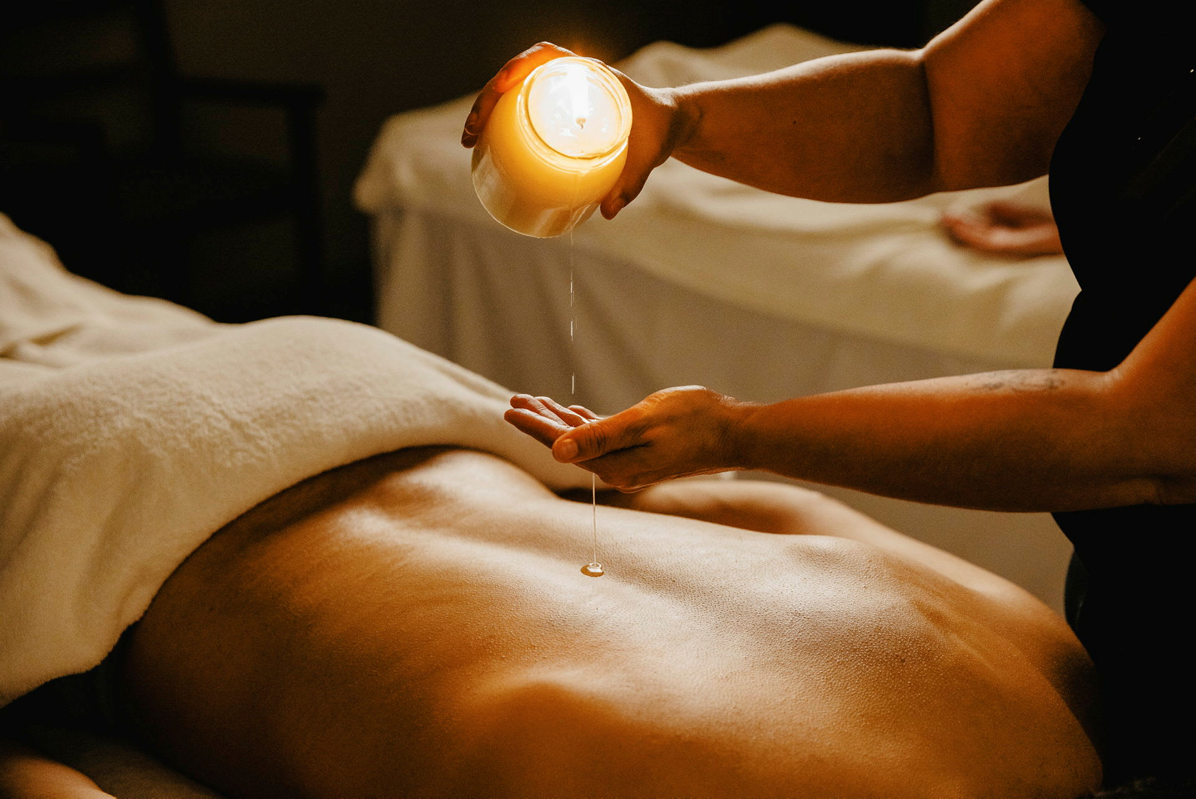 En person forbereder massage med lysolie på en ryg. (AI-genereret tekst)