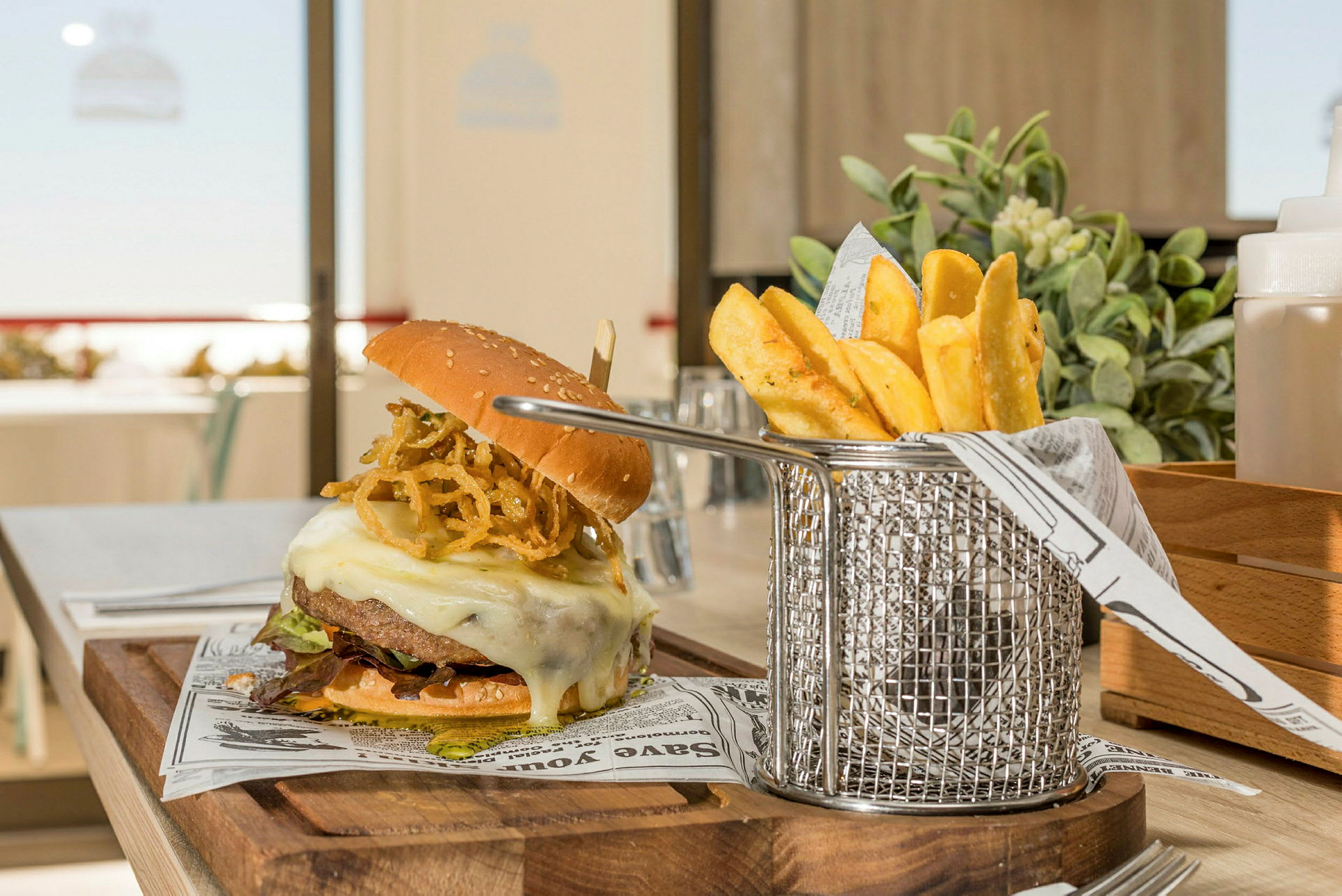 En hamburger med ost og pommes frites serveres. (AI-genereret tekst)