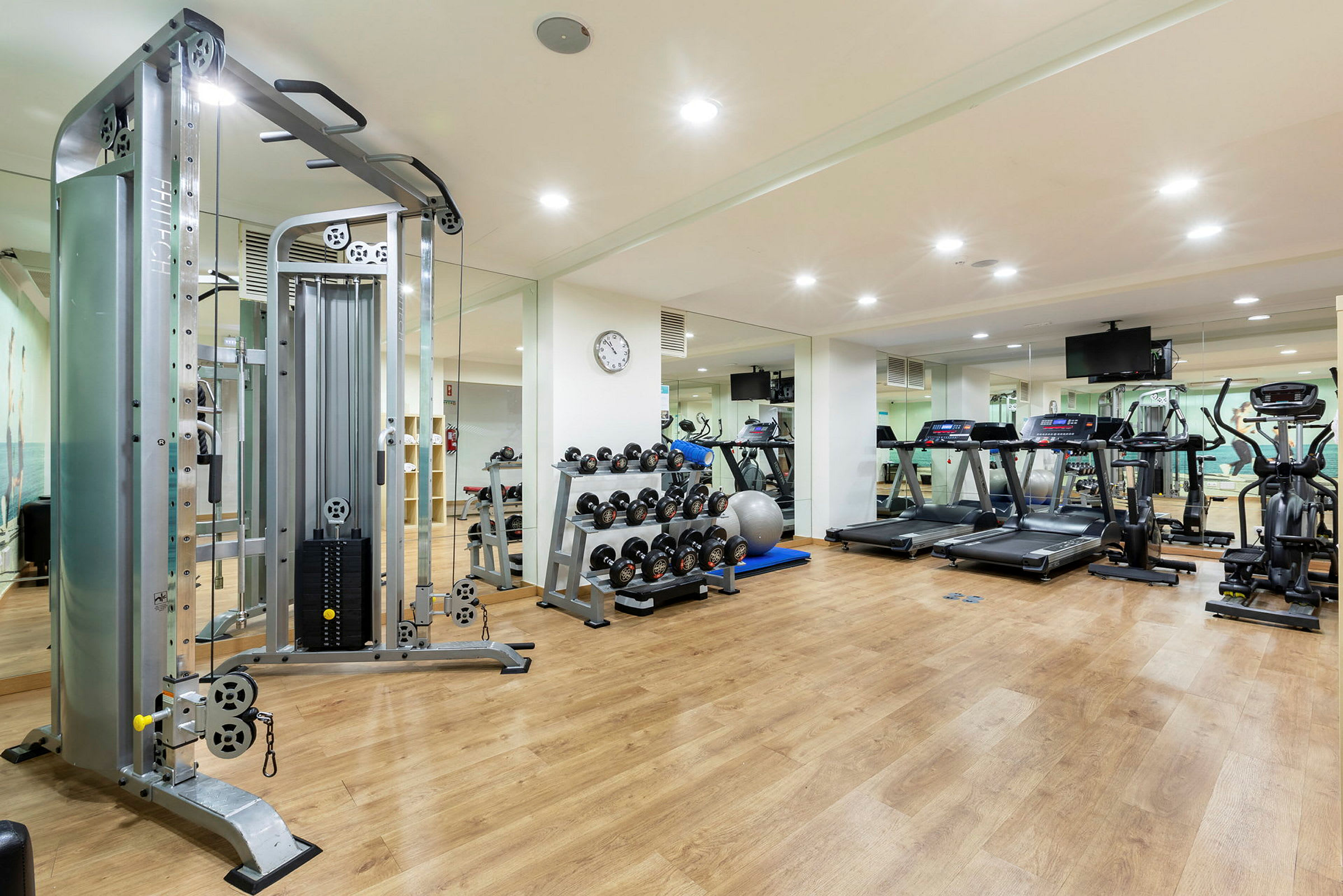 Fitnesscenter med træningsmaskiner og vægte. (AI-genereret tekst)