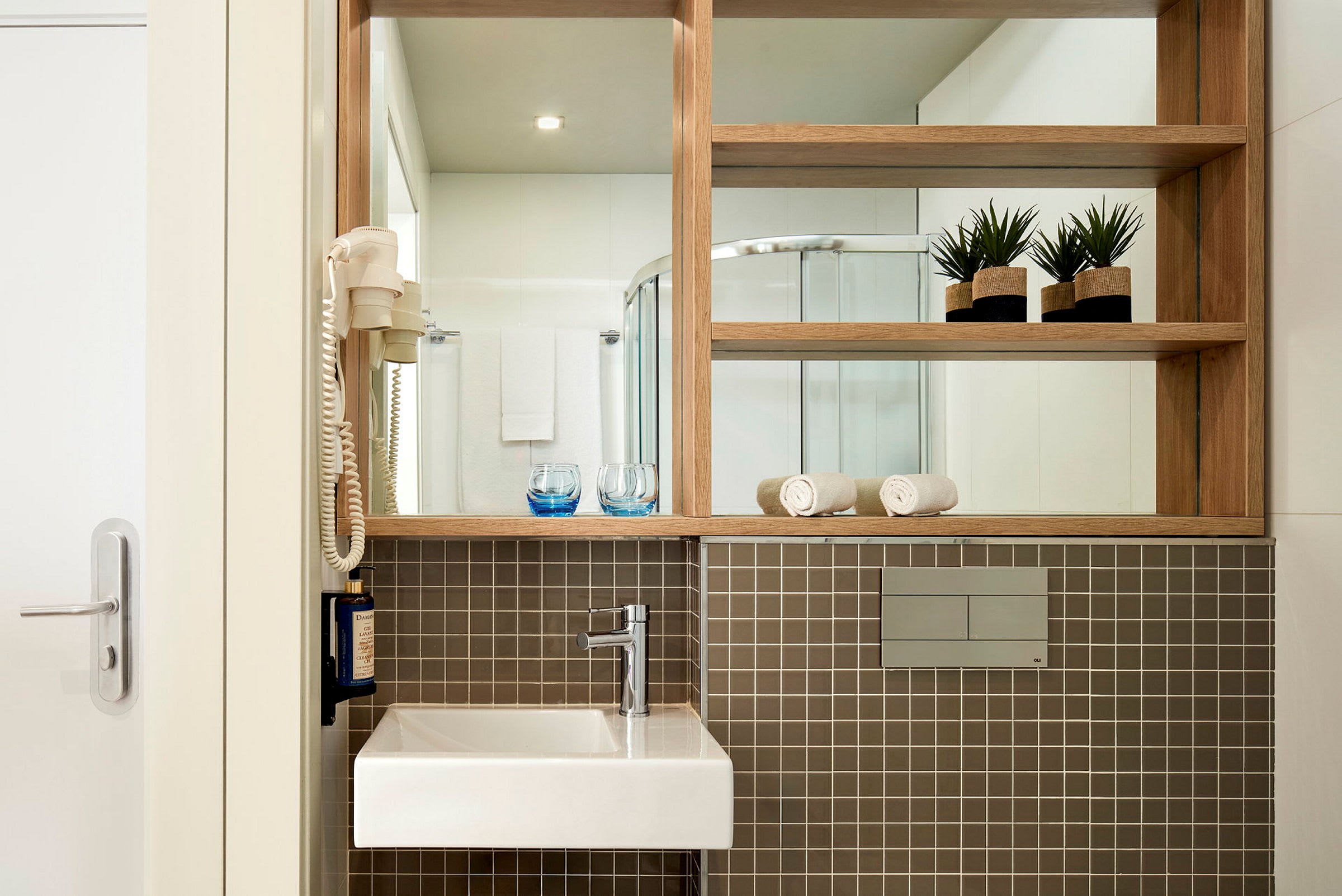 Moderne badeværelse med stilrent design, håndvask og brusebad. (AI-genereret tekst)