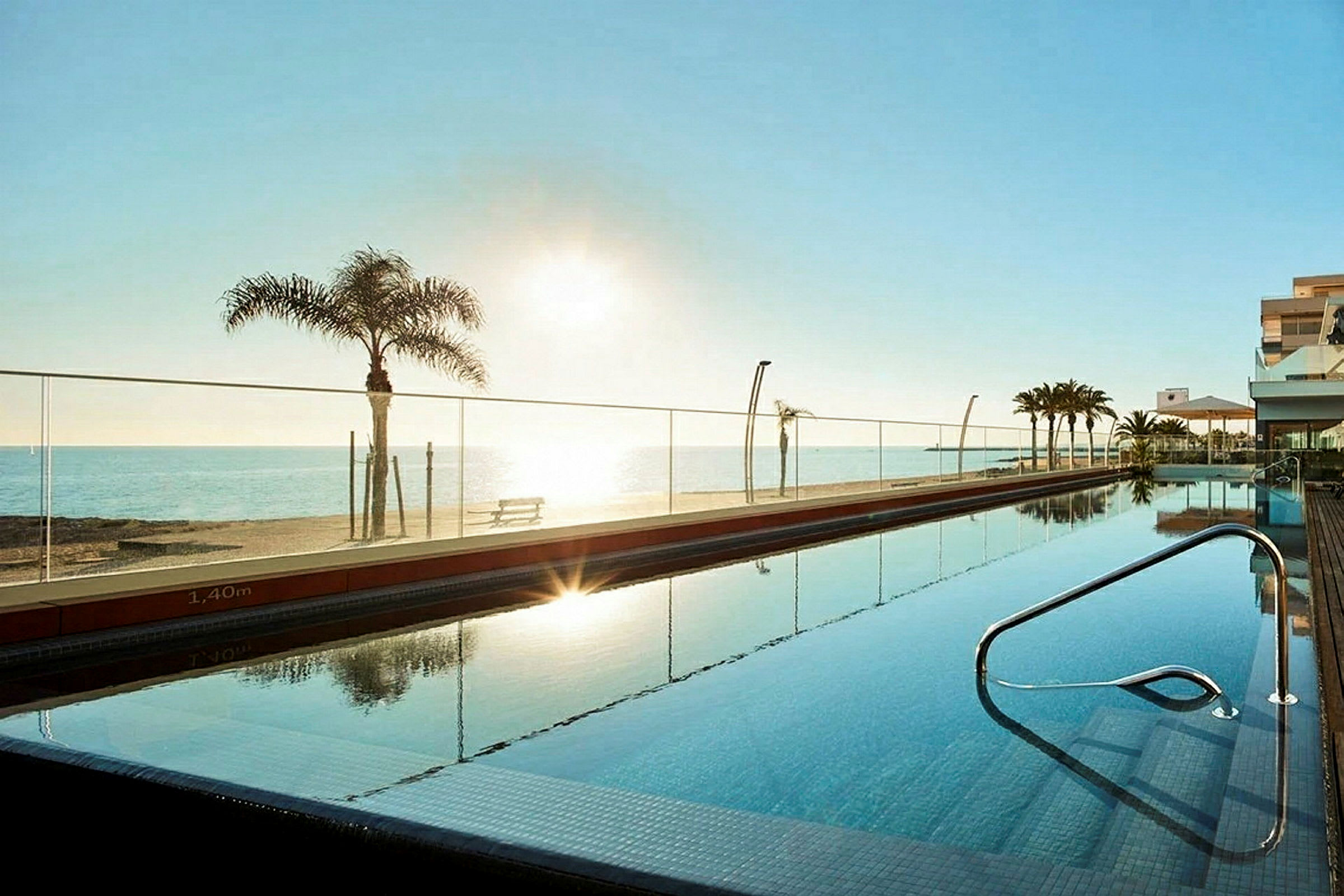 En swimmingpool ved et hotel med udsigt over stranden og havet. (AI-genereret tekst)