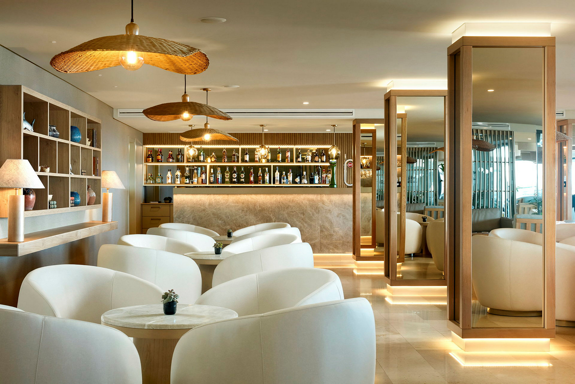 Billede af en moderne lounge med hvide lænestole, trædetaljer og en oplyst bar. (AI-genereret tekst)