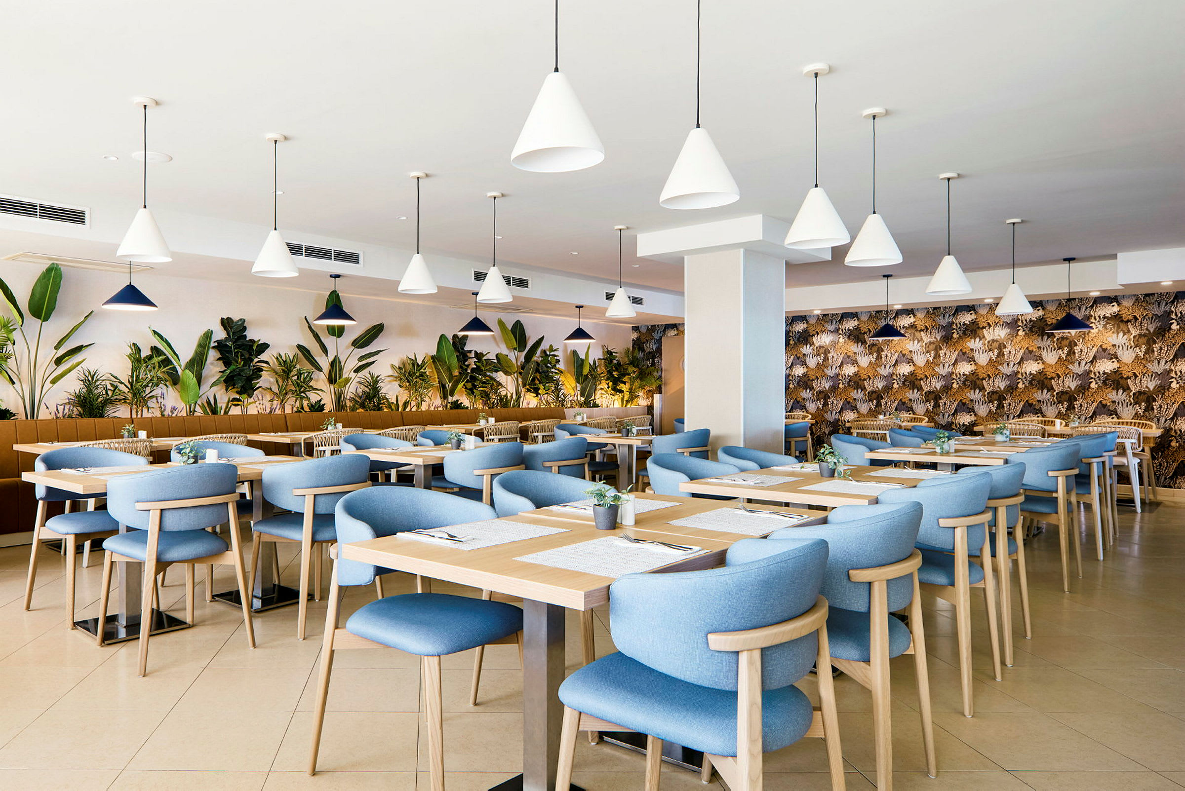 Restaurant med blå stole og træborde, omgivet af planter. (AI-genereret tekst)