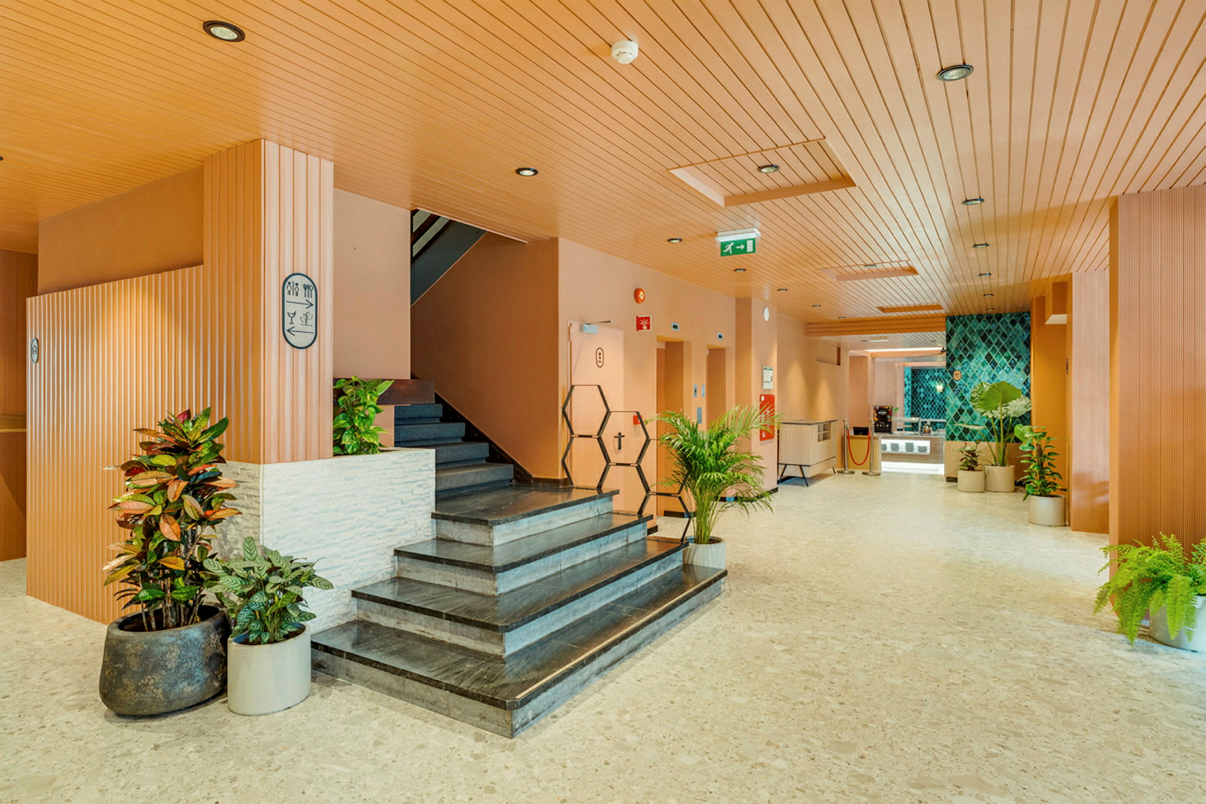 Hotellobby med trappe og dekorative planter. (AI-genereret tekst)