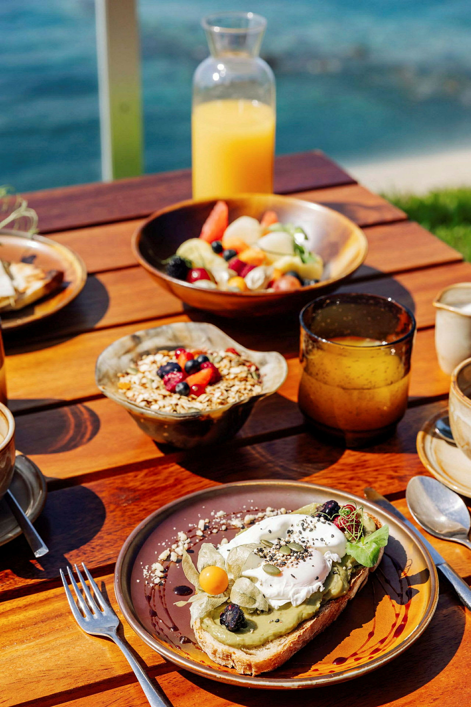 En morgenmad med juice, frugt, granola og avocadomad. (AI-genereret tekst)