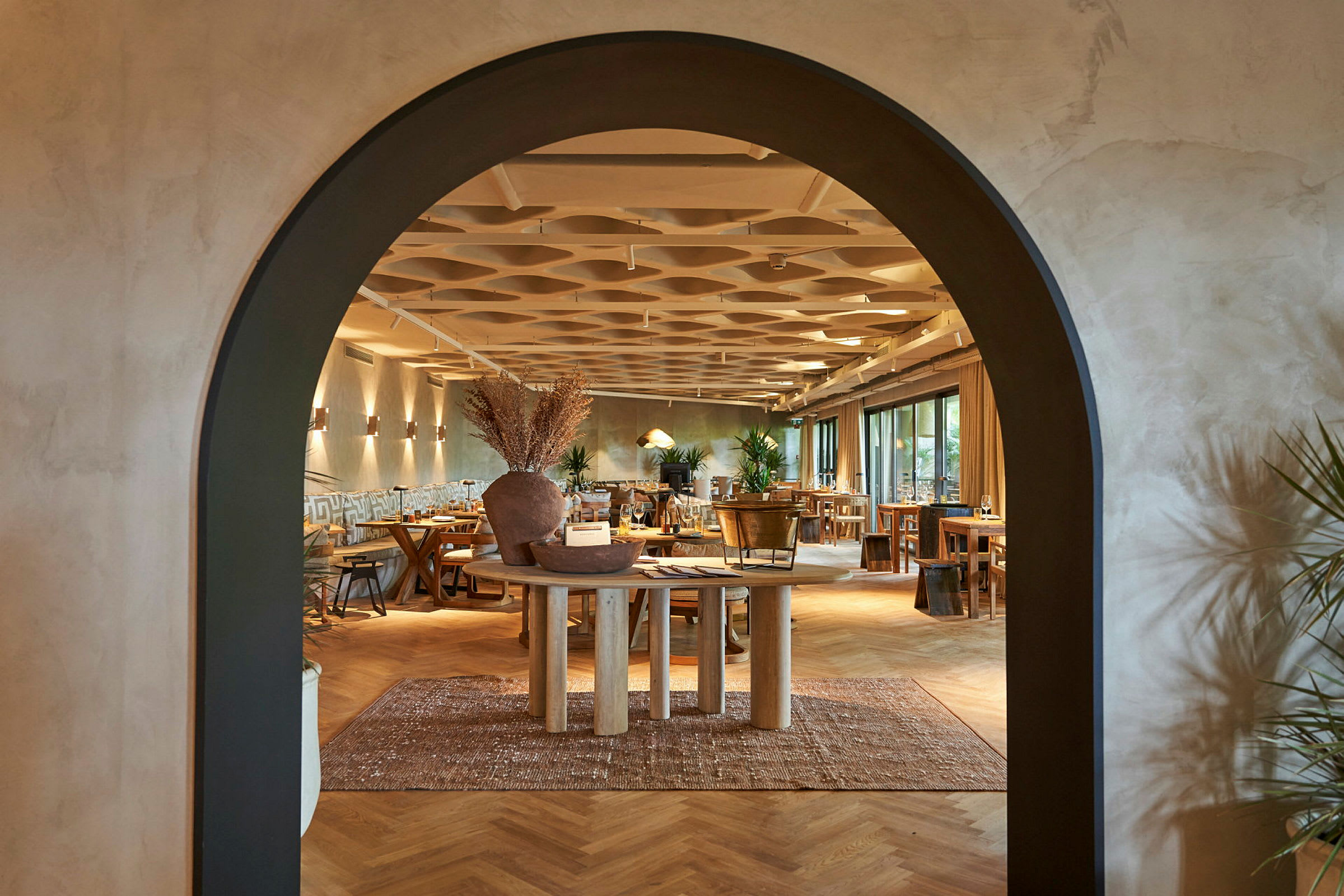 Arkitektur i en restaurant med en bue som åbning og trædetaljer i indretningen. (AI-genereret tekst)