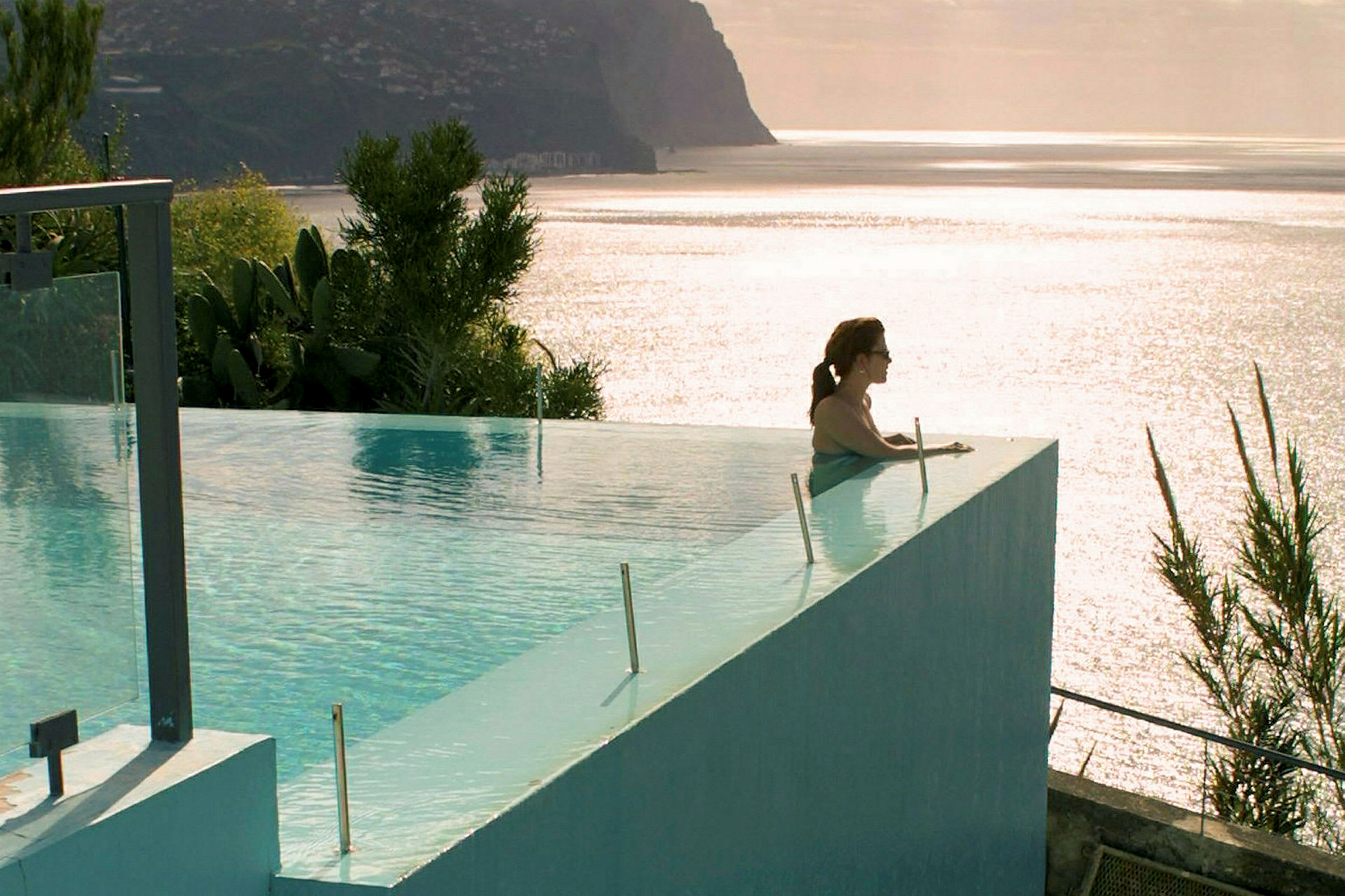 Infinity-pool med udsigt over havet og kystlandskab. (AI-genereret tekst)