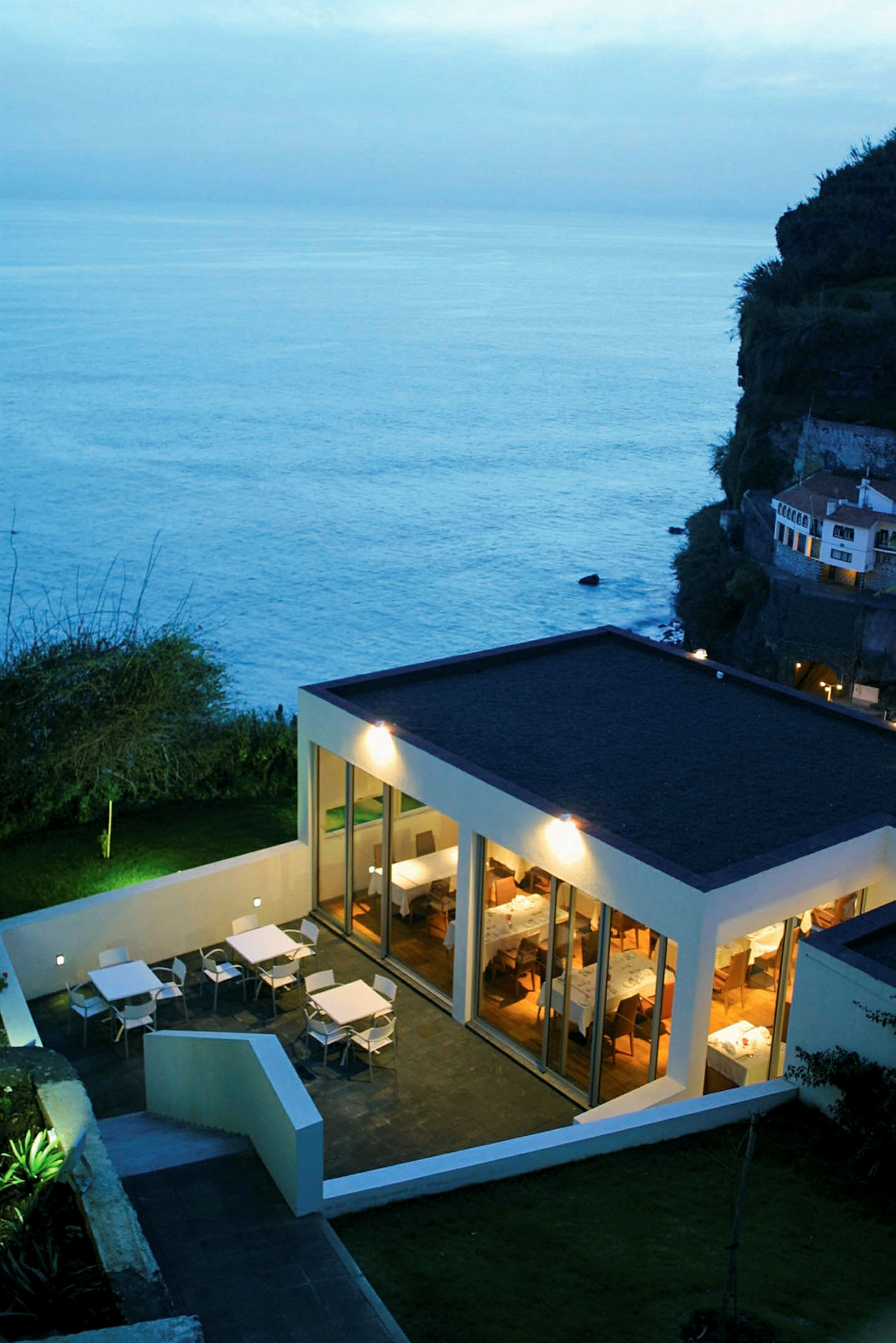 Moderne restaurant ved havet med terrasse til udendørs servering. (AI-genereret tekst)