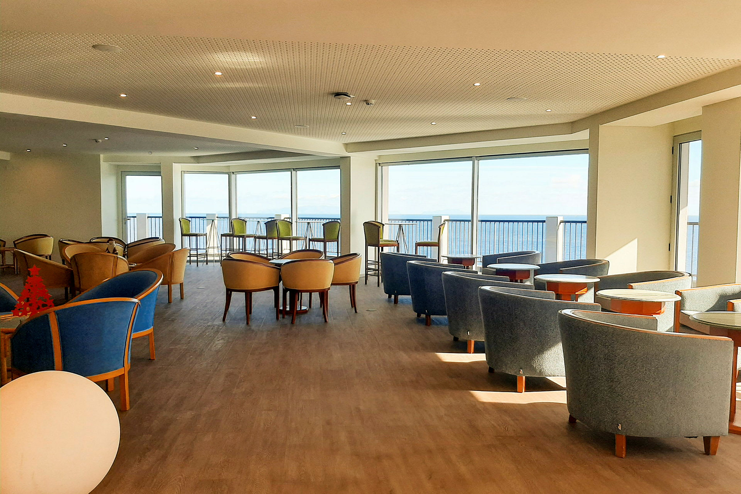 Et interiørbillede af en lys siddegruppe med udsigt over havet. (AI-genereret tekst)