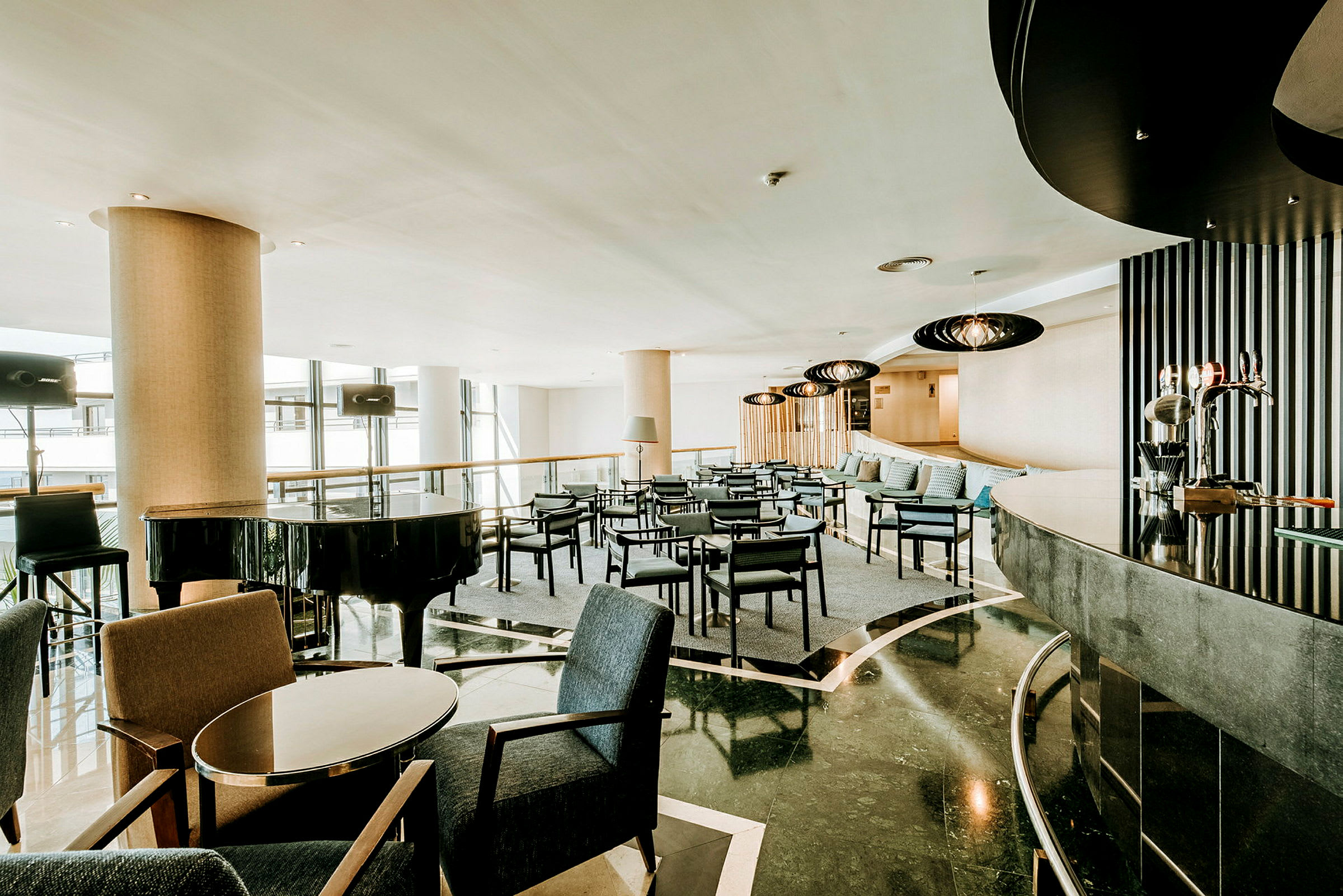 En moderne hotellobby med siddegrupper og et sort flygel. (AI-genereret tekst)