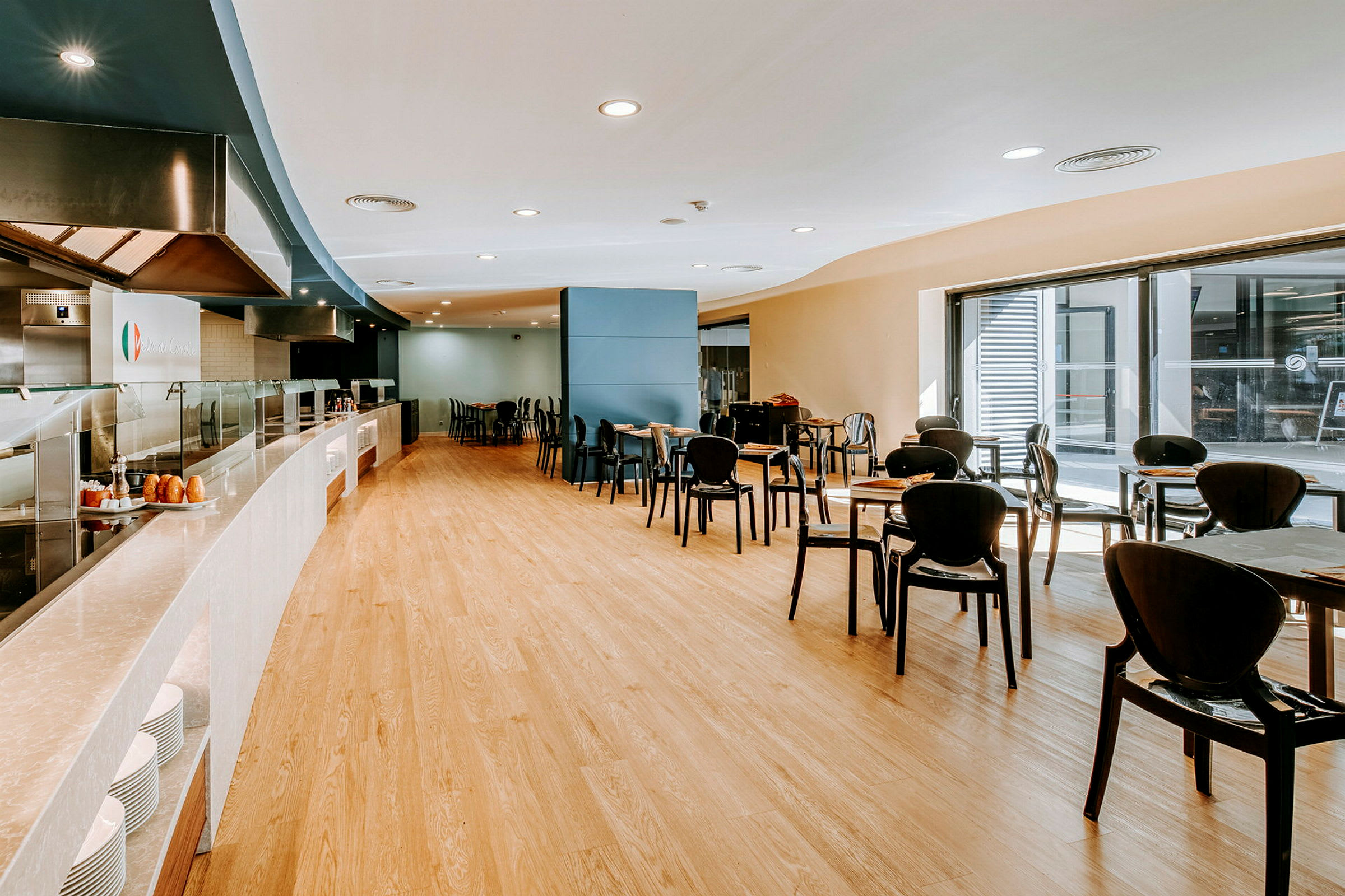 En spiserestaurant med borde og stole og en buffét disk. (AI-genereret tekst)