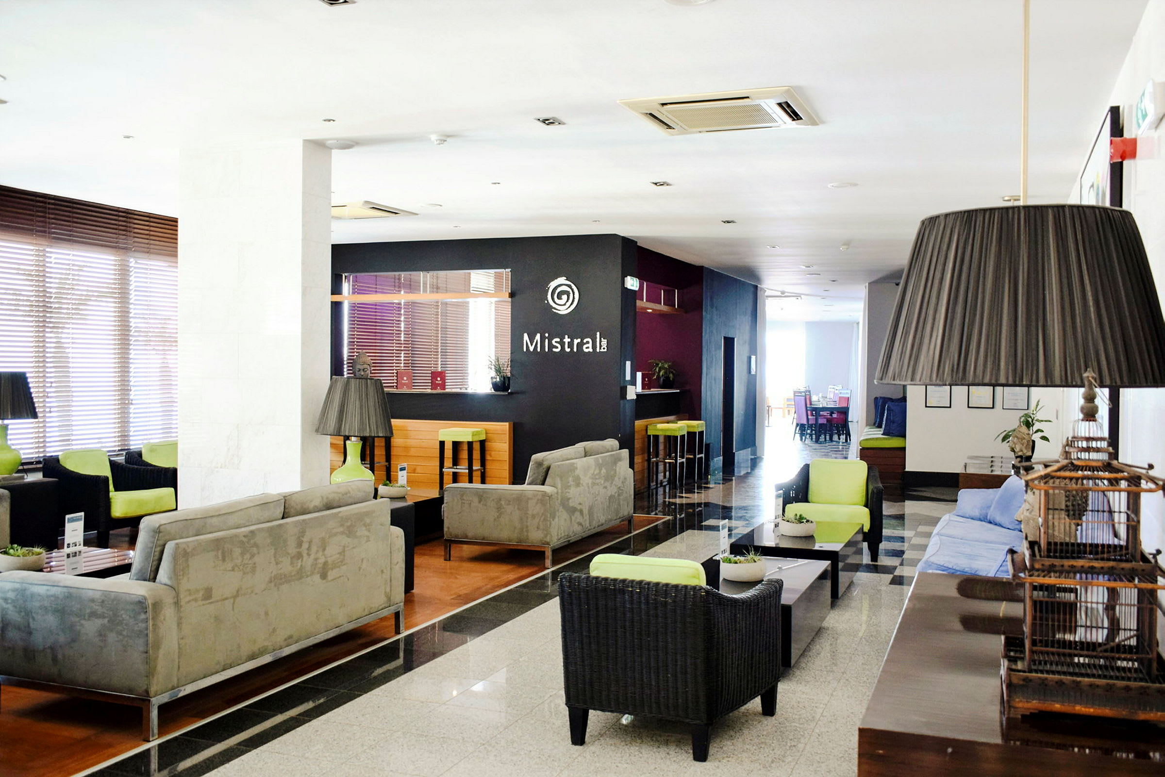 En hotellobby med sofaer, borde og en bar i baggrunden. (AI-genereret tekst)