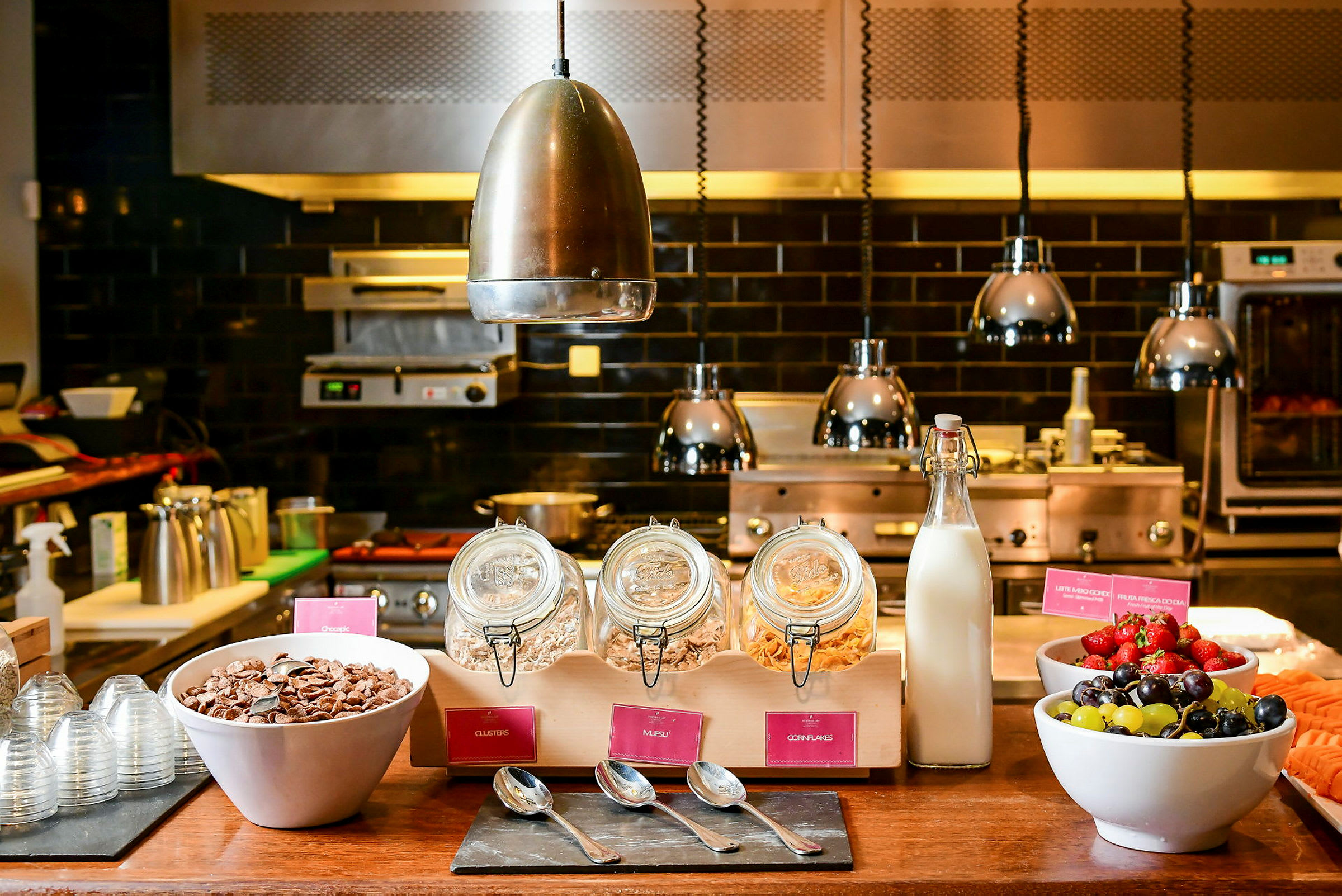 En morgenmadsbuffet med morgenmadsprodukter, mælk og frugt serveres på et bord. (AI-genereret tekst)