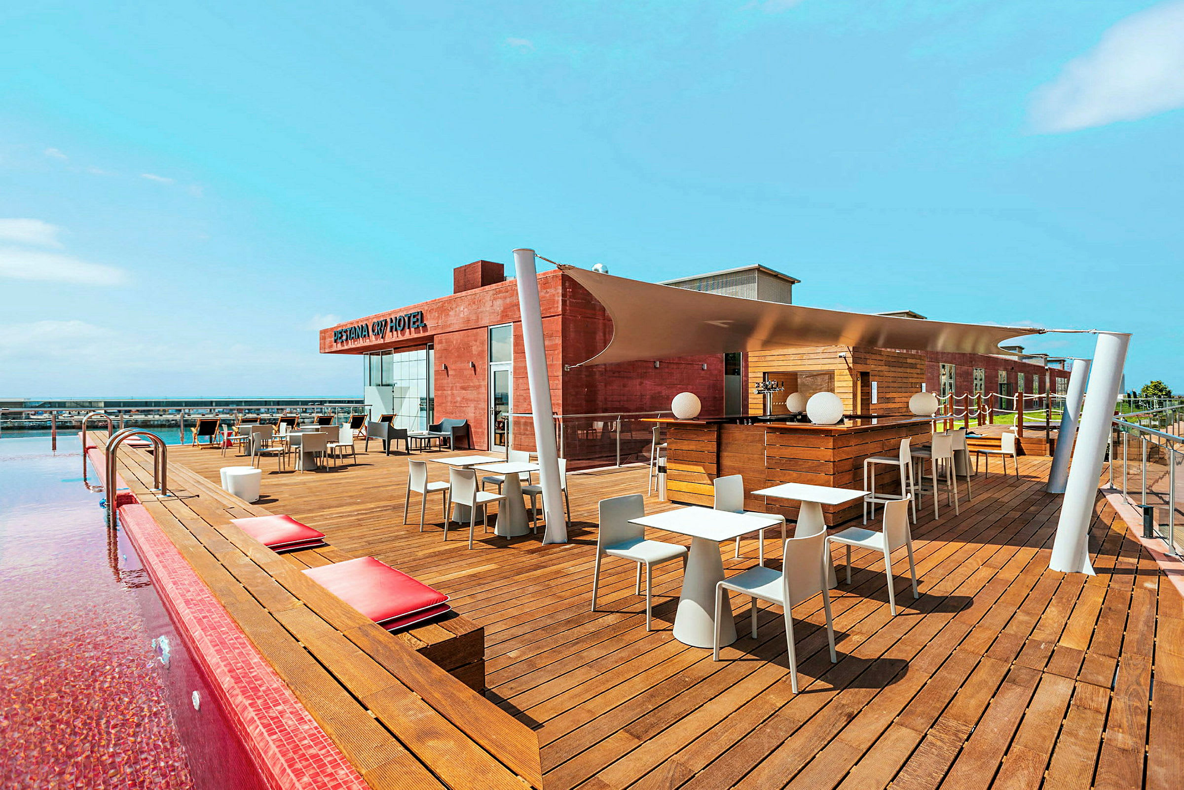 Tagterrasse med pool, siddepladser og bar ved et hotel. (AI-genereret tekst)