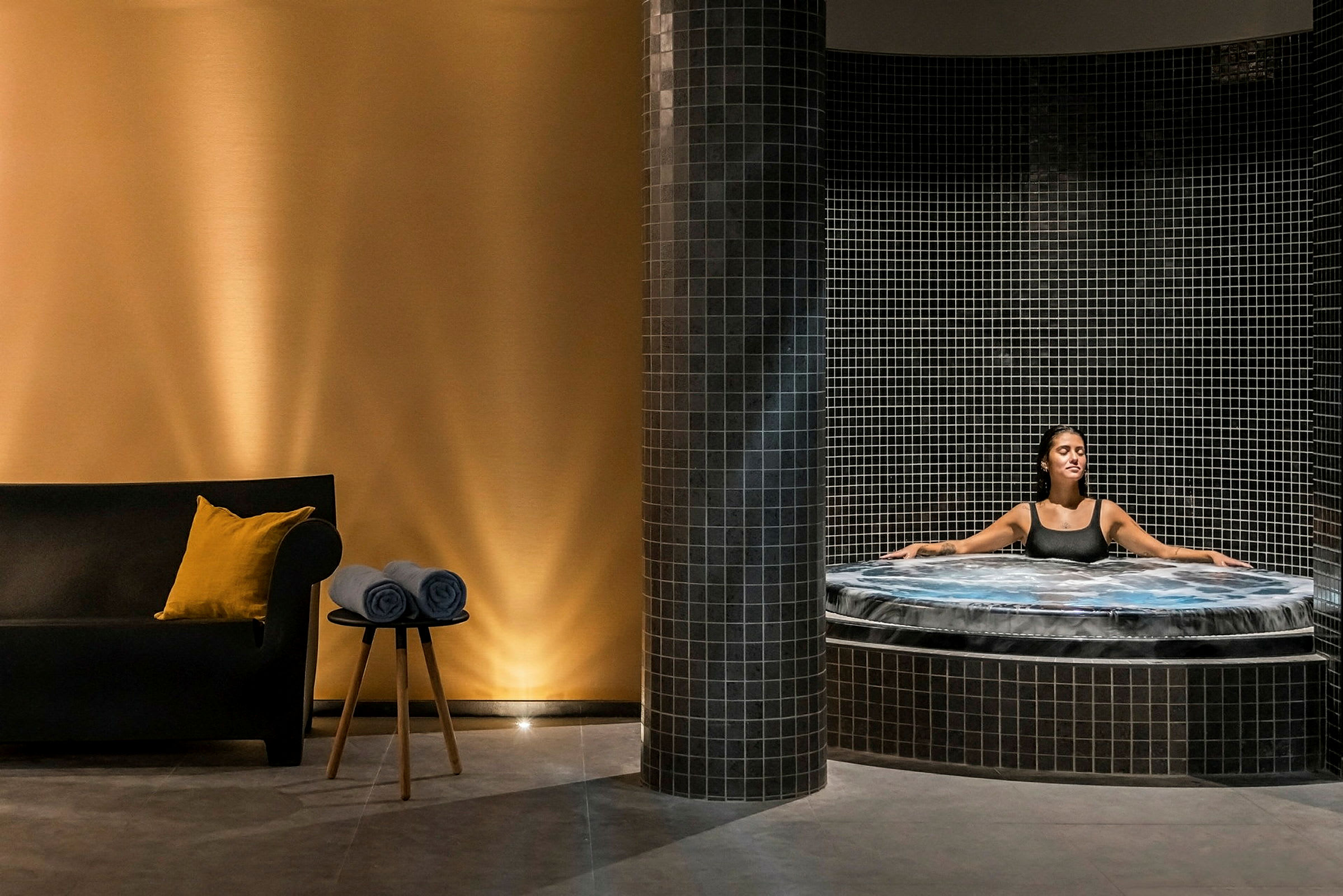 Et afslappende miljø med en jacuzzi og et siddeområde. (AI-genereret tekst)