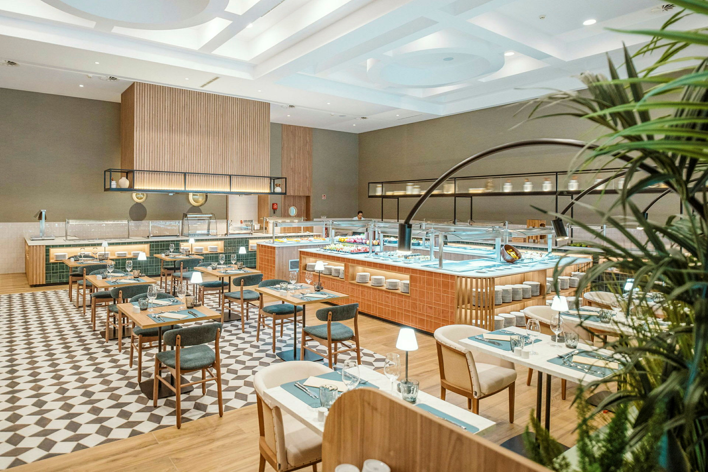 En rummelig og moderne restaurant med træborde og stole, stilfuldt dekoreret og med en buffetdisk i fokus. (AI-genereret tekst)