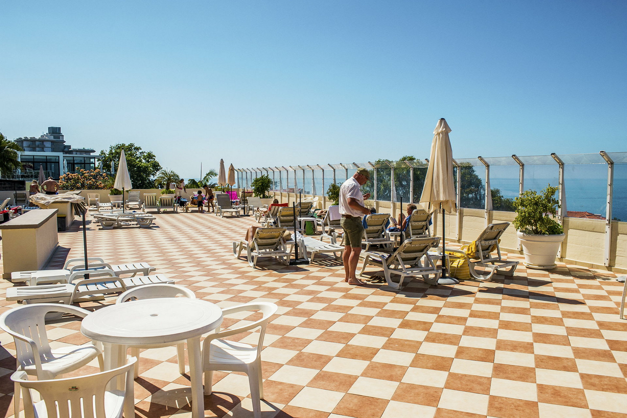 En solterrasse med liggestole og parasoller samt havudsigt. (AI-genereret tekst)
