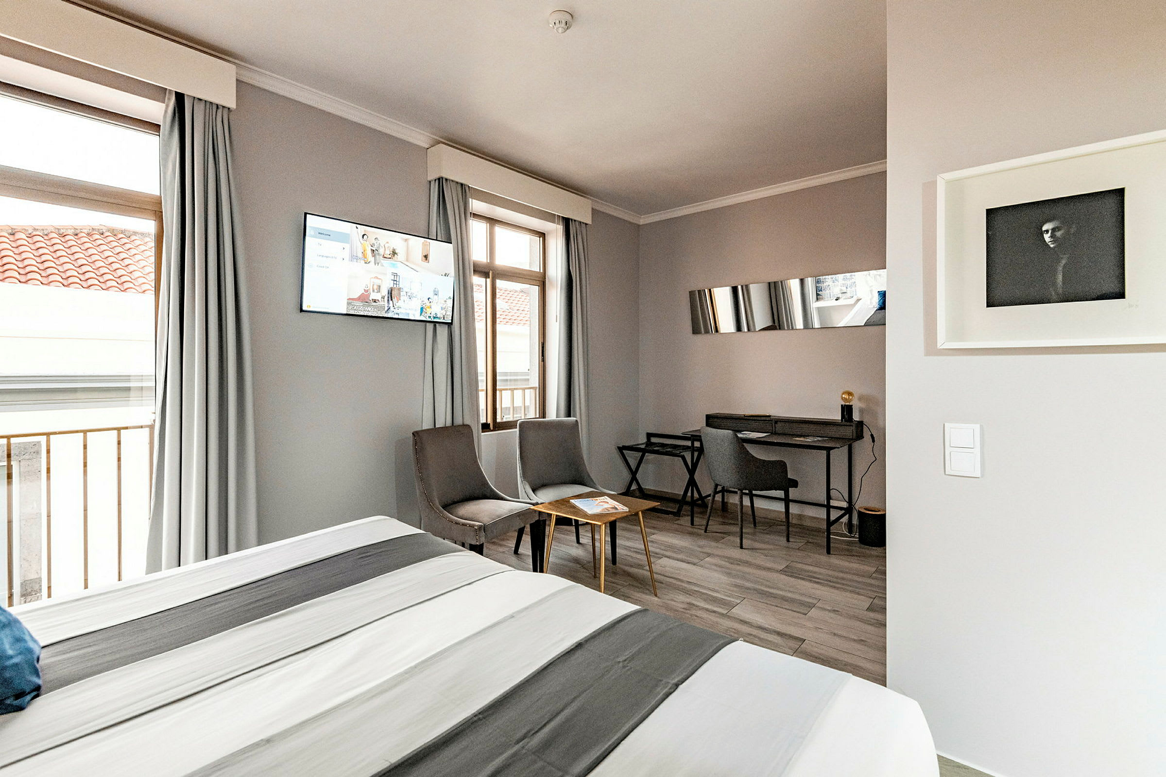 Interiør af et hotelværelse med en seng, siddeområde og skrivebord. (AI-genereret tekst)